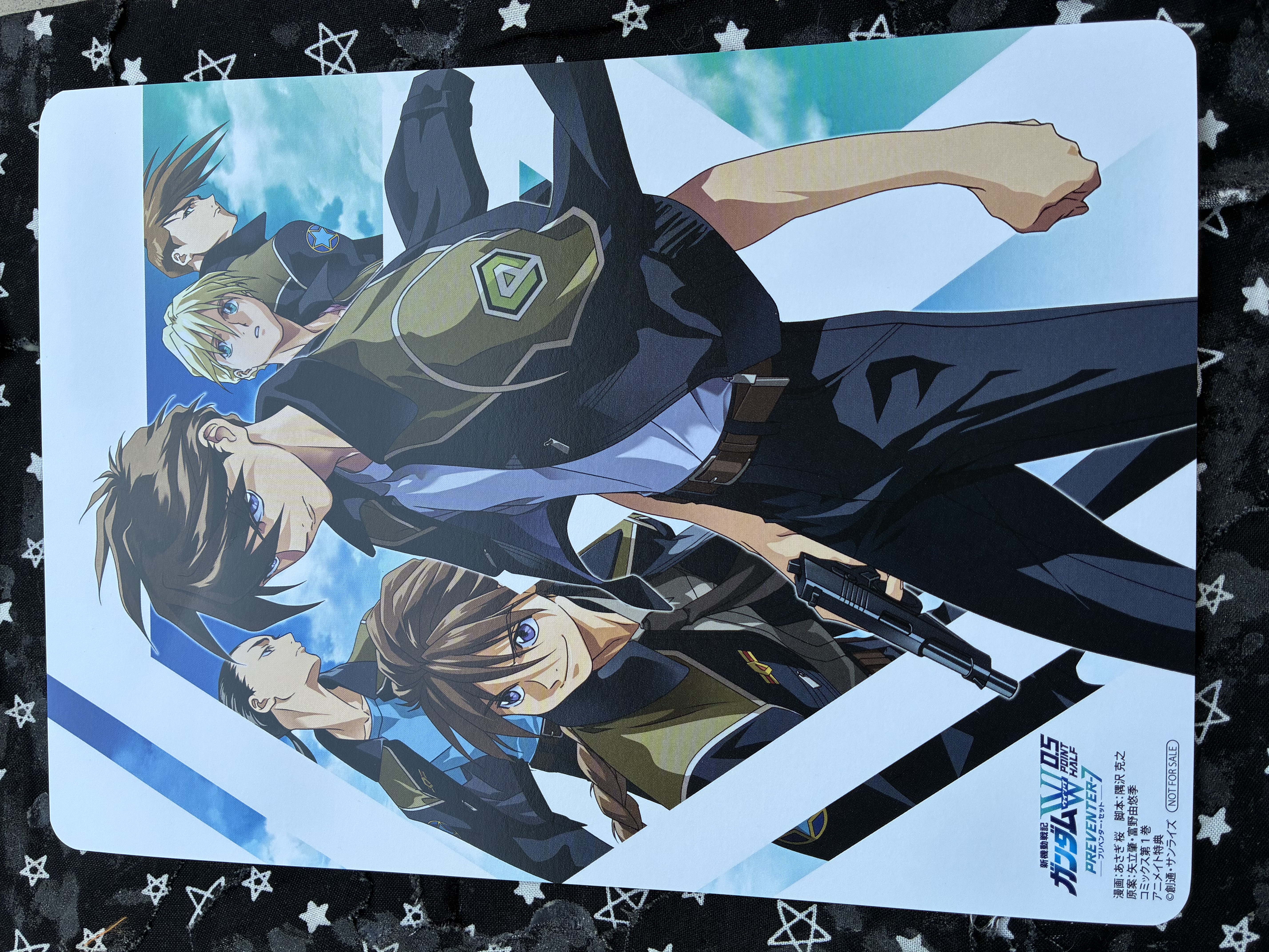 Poster board of the Gundam wing boys in their Preventer outfits with Heero in the center holding a gun.