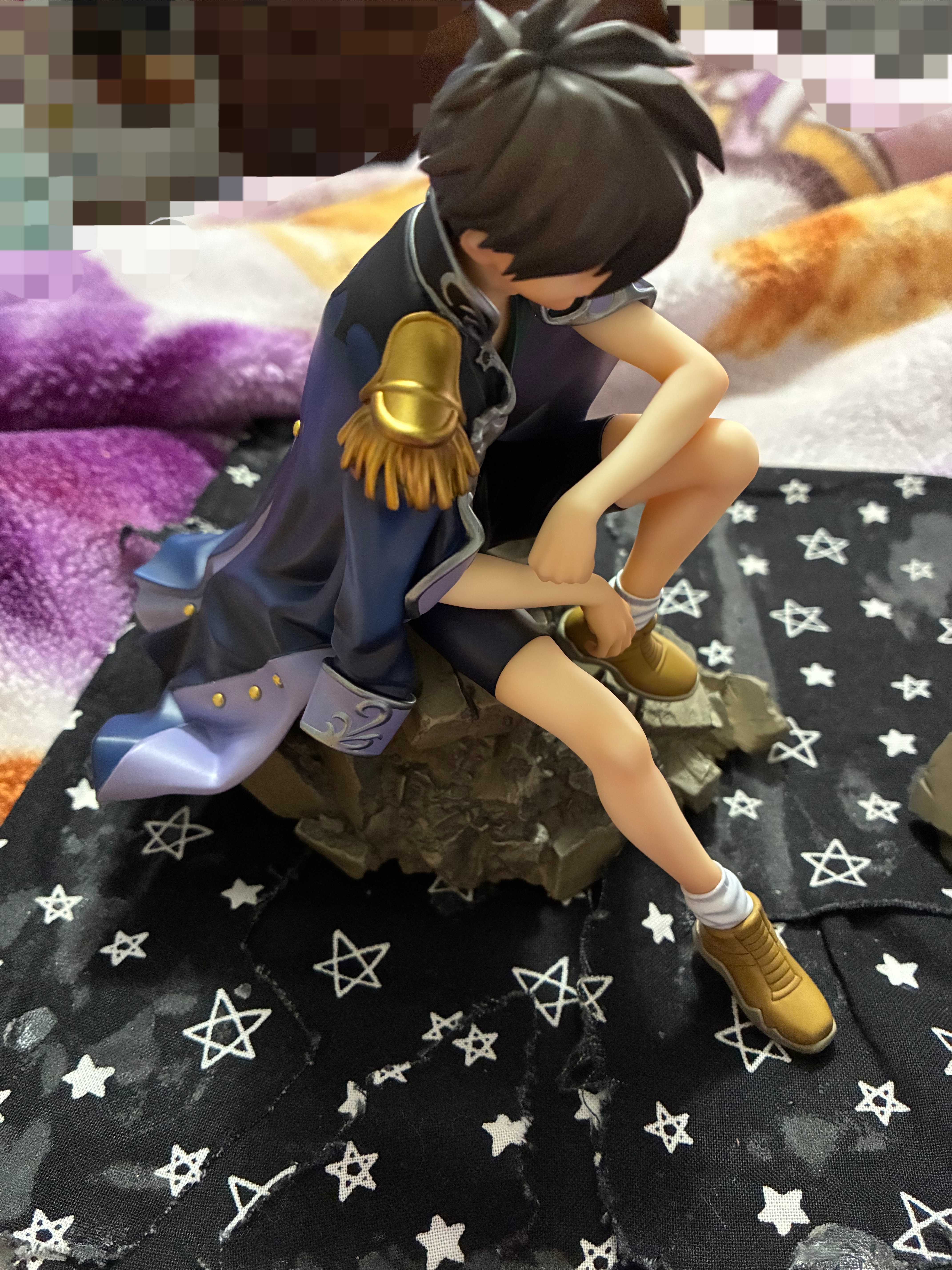 Figure of Gundam wing Heero sitting on rubble.
