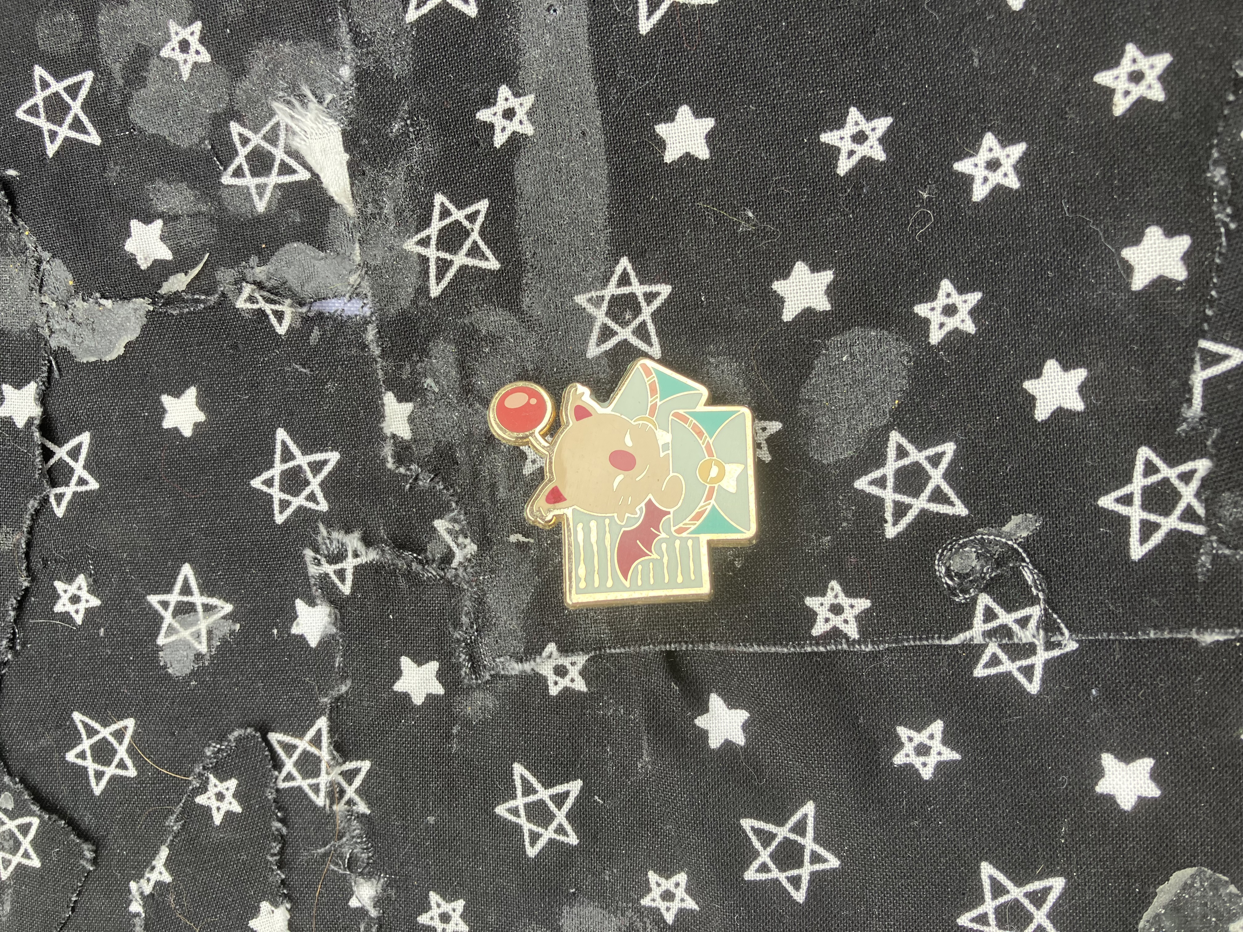 Enamel pin of final fantasy moogle surrounded by a letter paper and envelopes.