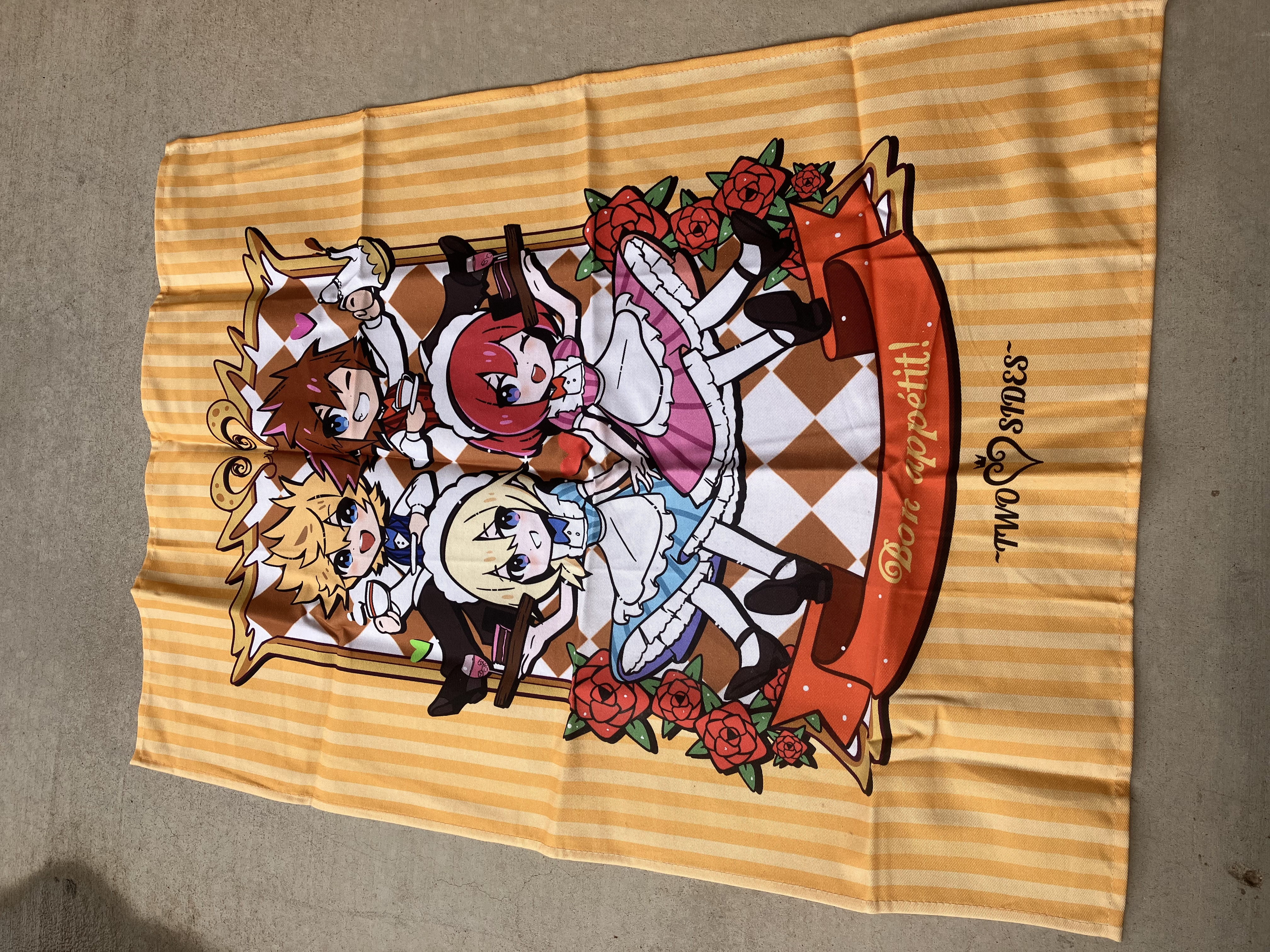 Fabric poster of chibi-style Kingdom hearts Namine, Kairi, Sora. and Roxas in cafe uniforms within a checkered border with the phrase Bon appétit