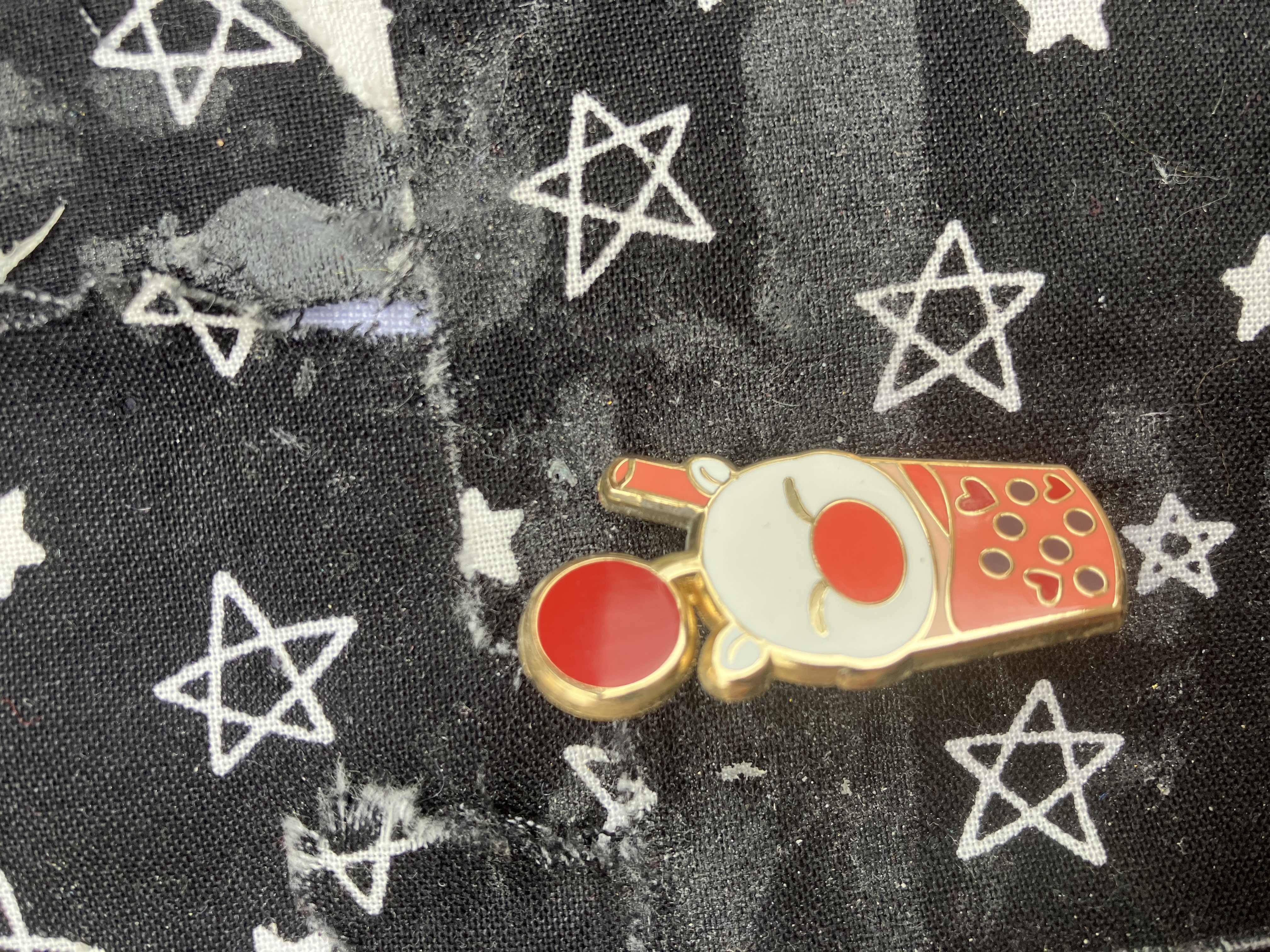 Enamel pin of a boba cup shaped like a Kingdom hearts moogle.