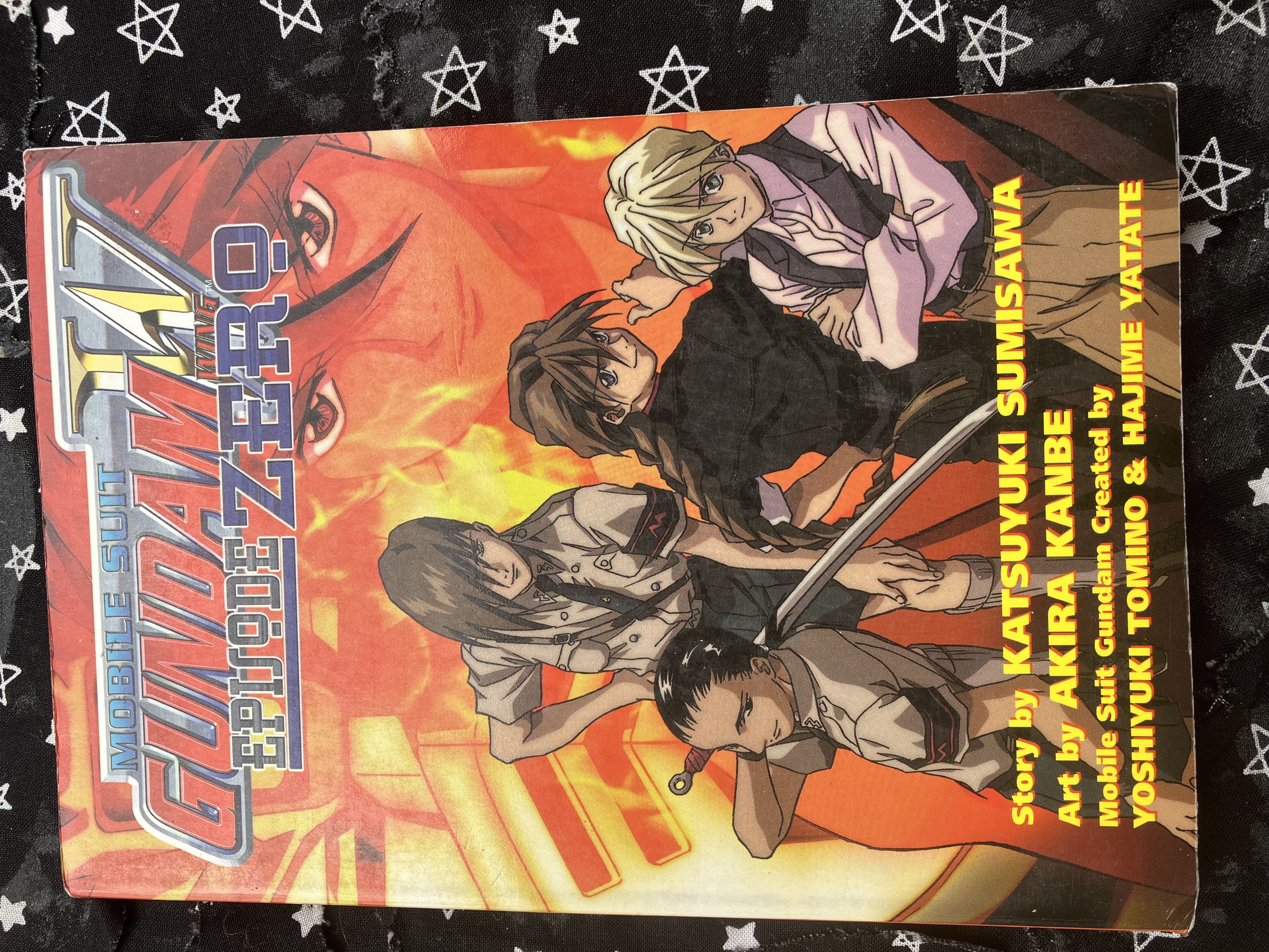 Front of Mobile Suit Gundam Wing: Episode Zero with the wing boys amd wing gundam on the cover. Trowa and Wufei are wearing Mariemaia army outfit.