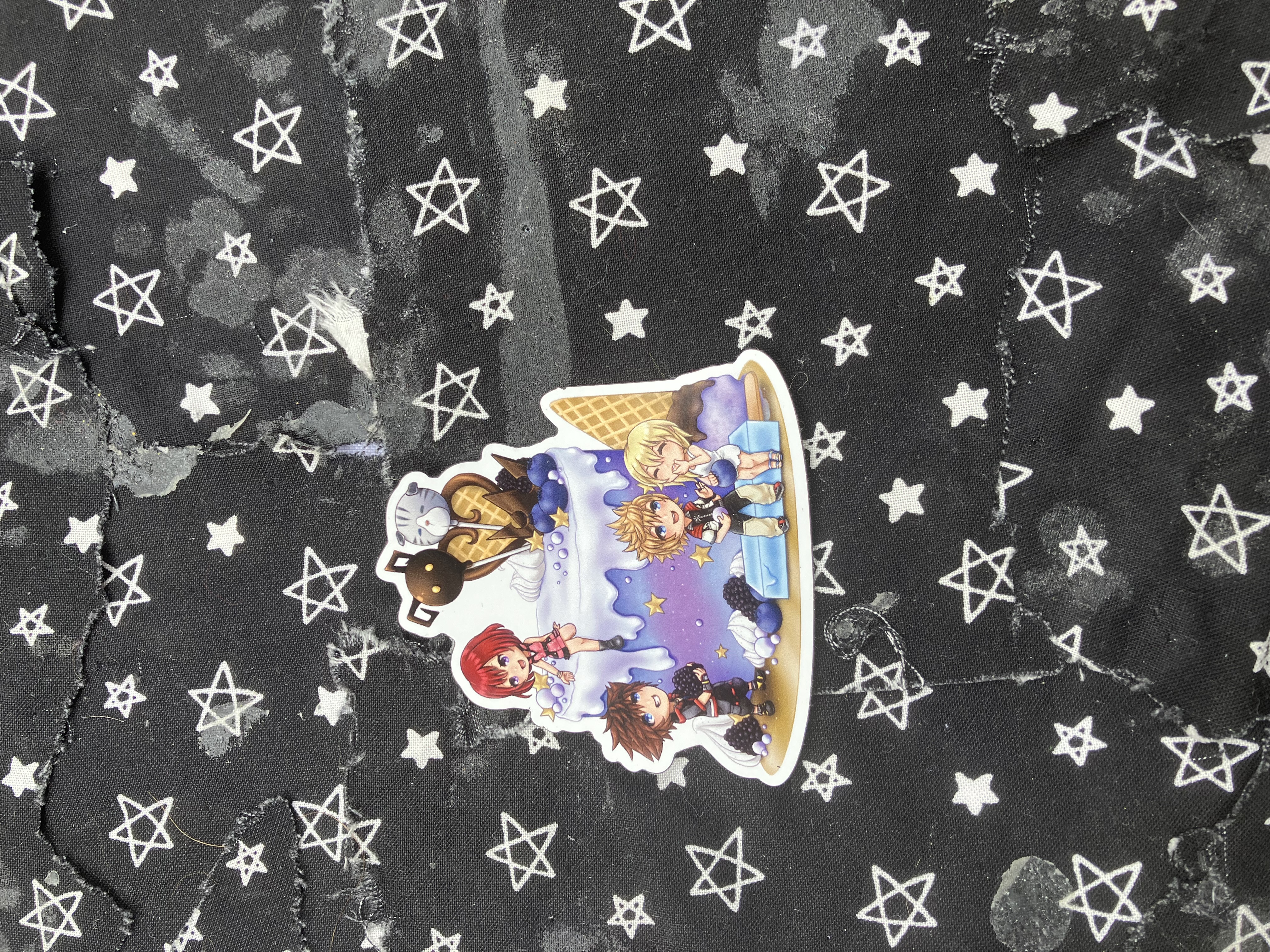 Magnet of chibi Kingdom hearts Namine and Roxas sitting on a sea salt ice cream while Kairi and Sora are near a Kingdom hearts themed cake.