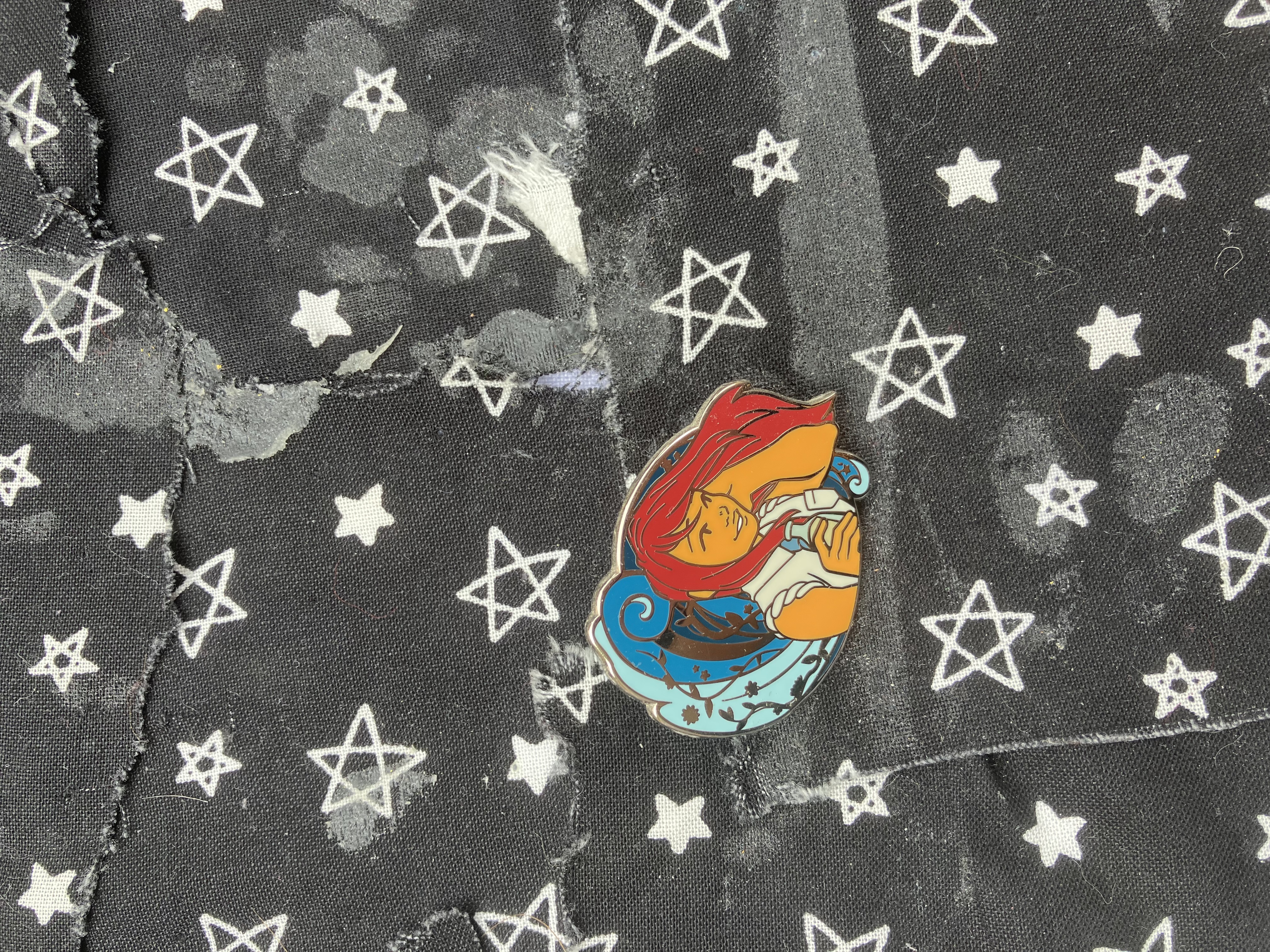 Enamel pin of Kingdom hearts Kairi in her school uniform holding her hair and holding a botttle in her other hand while a wave surrounds her.