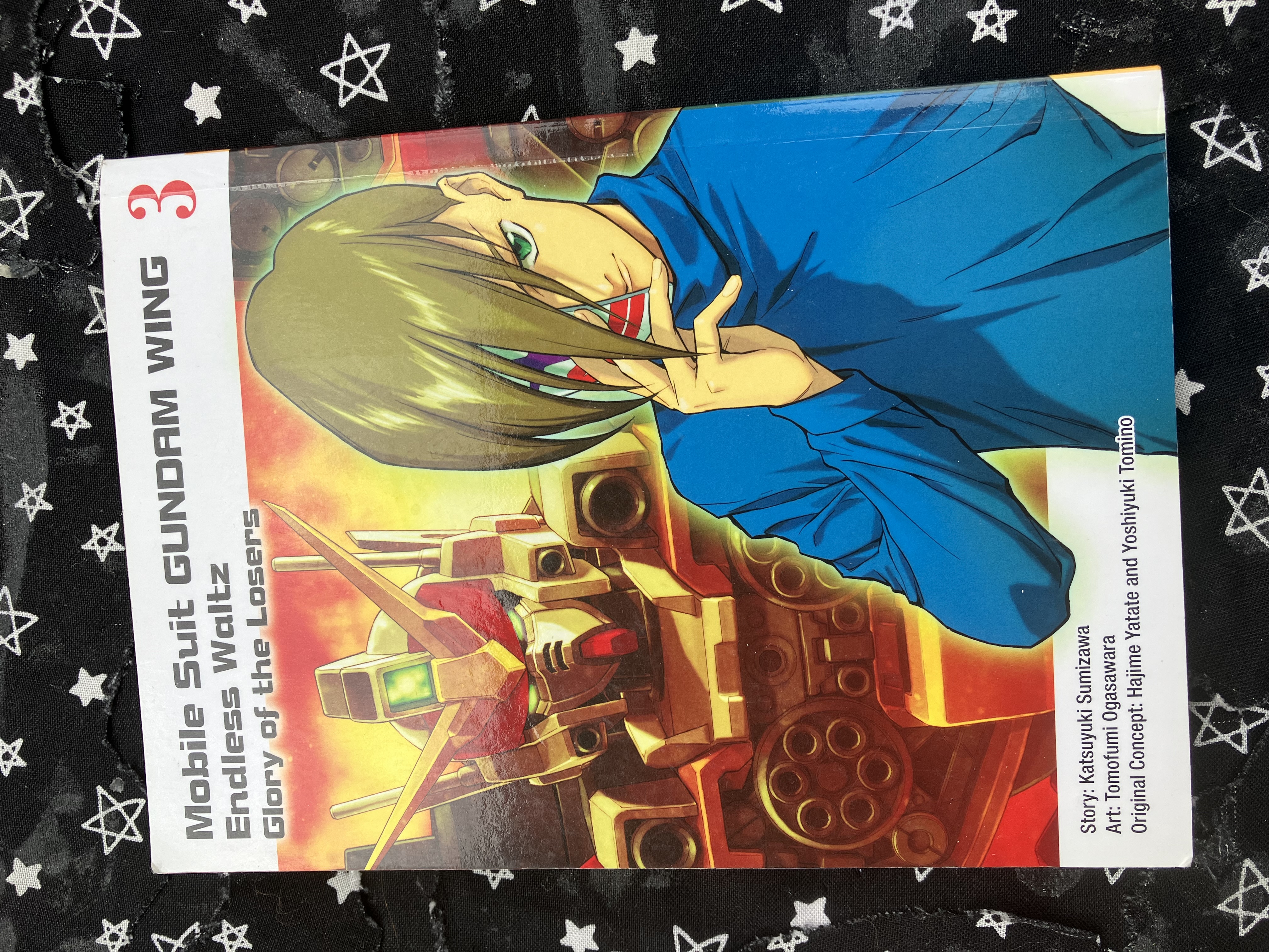 Front of Mobile Suit Gundam WING 3: Glory of the Losers with Heavyarms and Trowa wearing half of a clown mask.