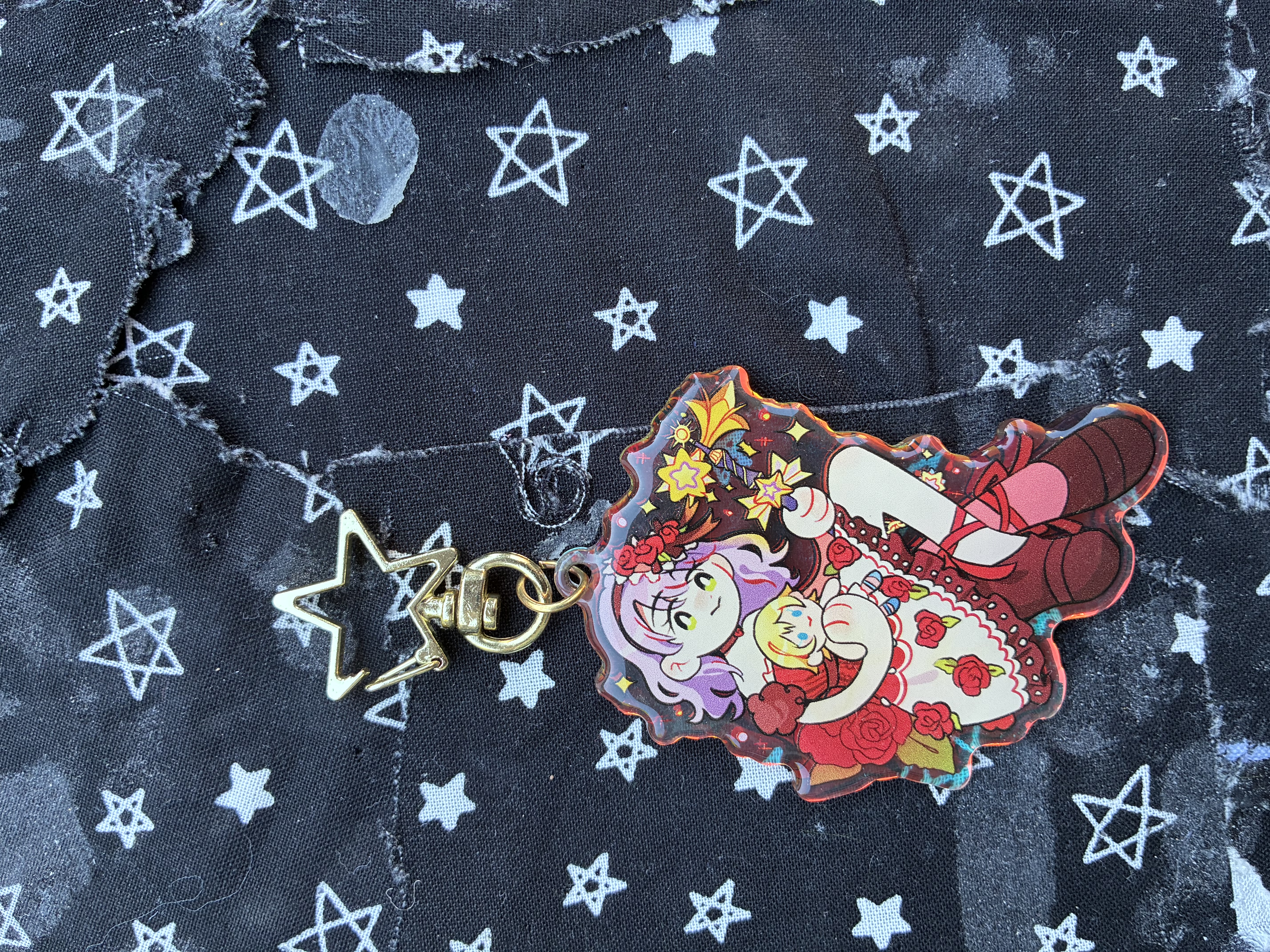 Acrylic charm of my Kingdom hearts keykid Fish dressed in a rose designed dress holding a Namine doll and her keyblade, decorated with red roses and gold stars.