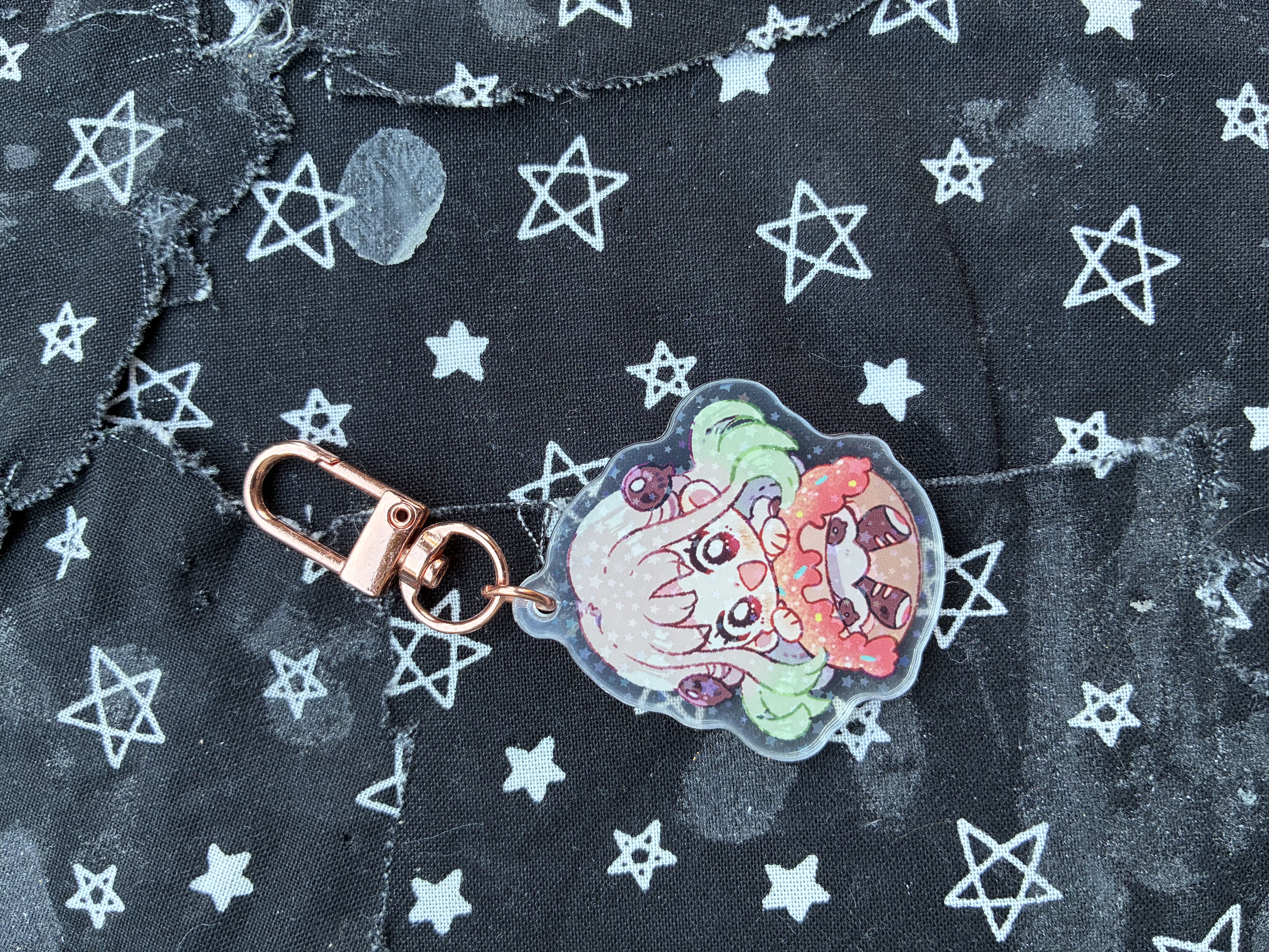 Acrylic charm of Jibaku shounen hanako Nene stuck in a pink icing with sprinkles donut with a smile on her face.