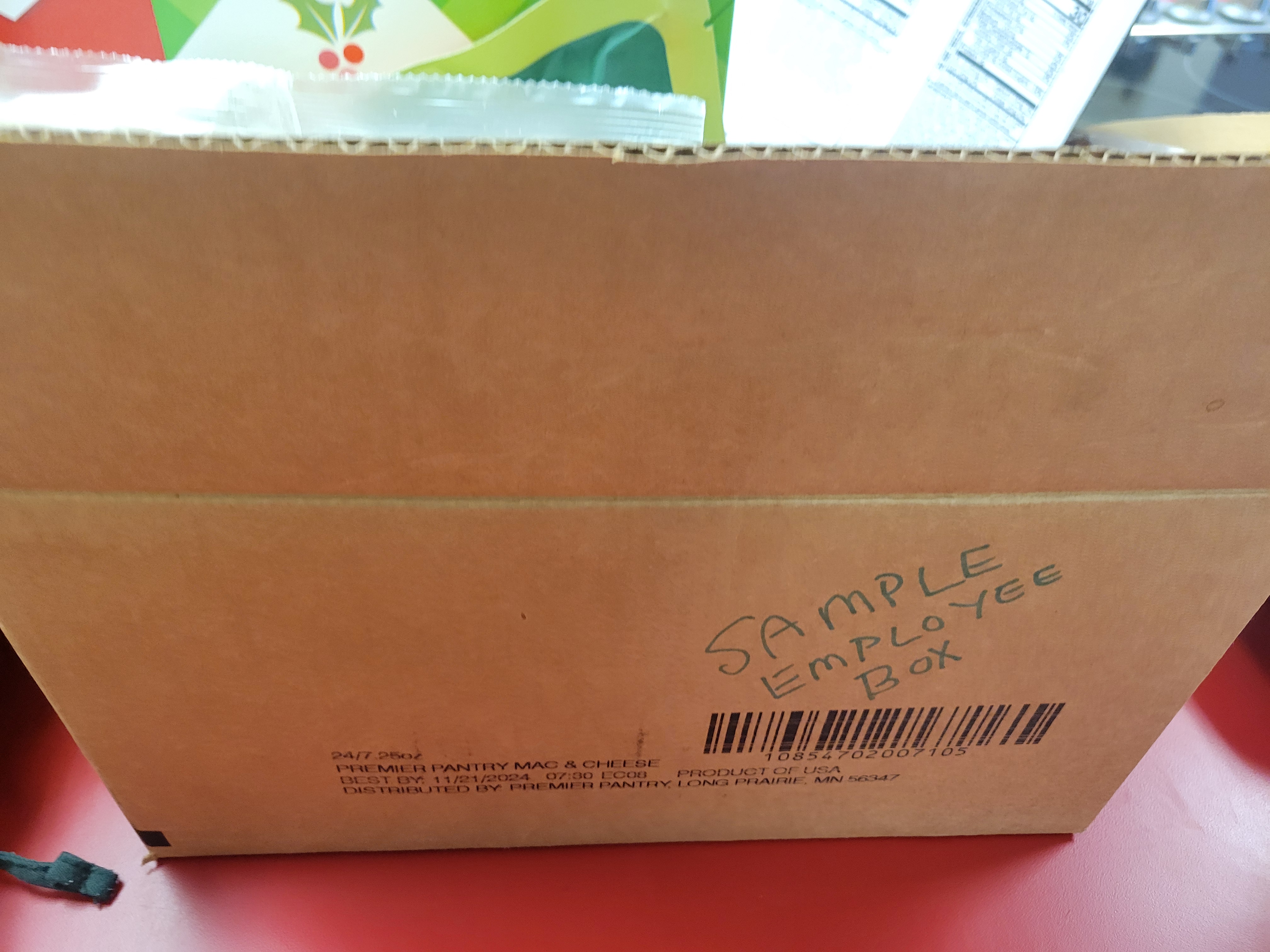 Cardboard box that has the words employee sample box written on it.
