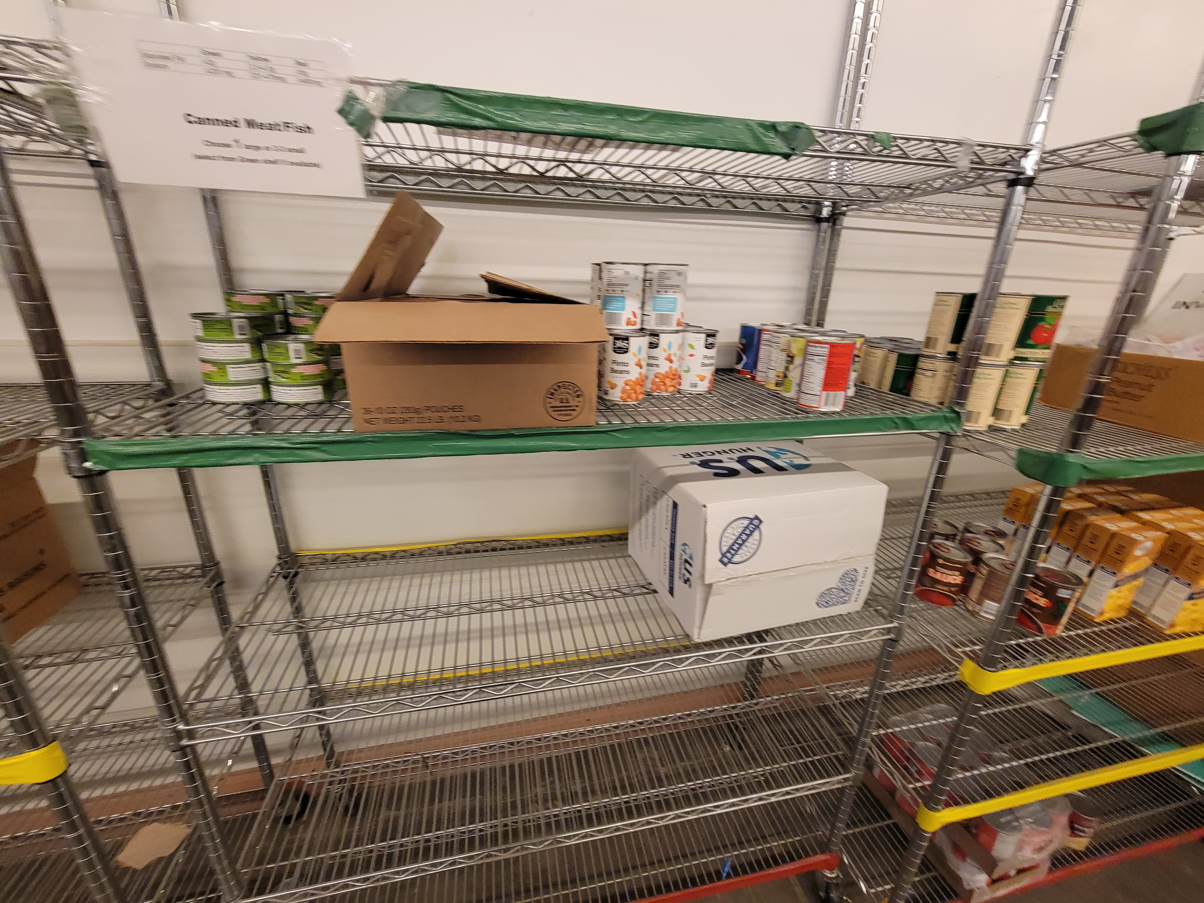Shelves of canned food and pouches of chicken.