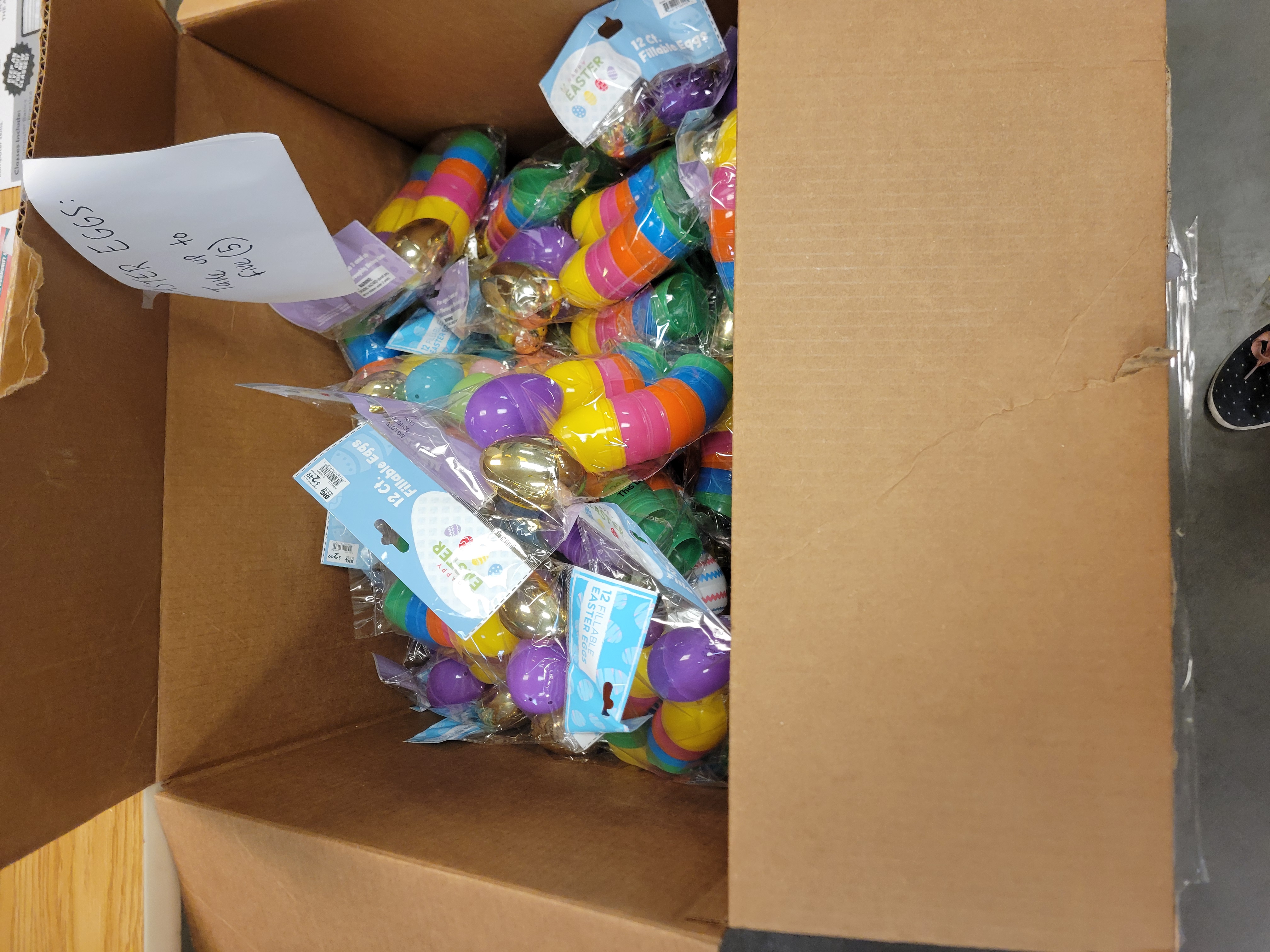 Box full of bags of plastic easter eggs with a sign that says take up to 5.