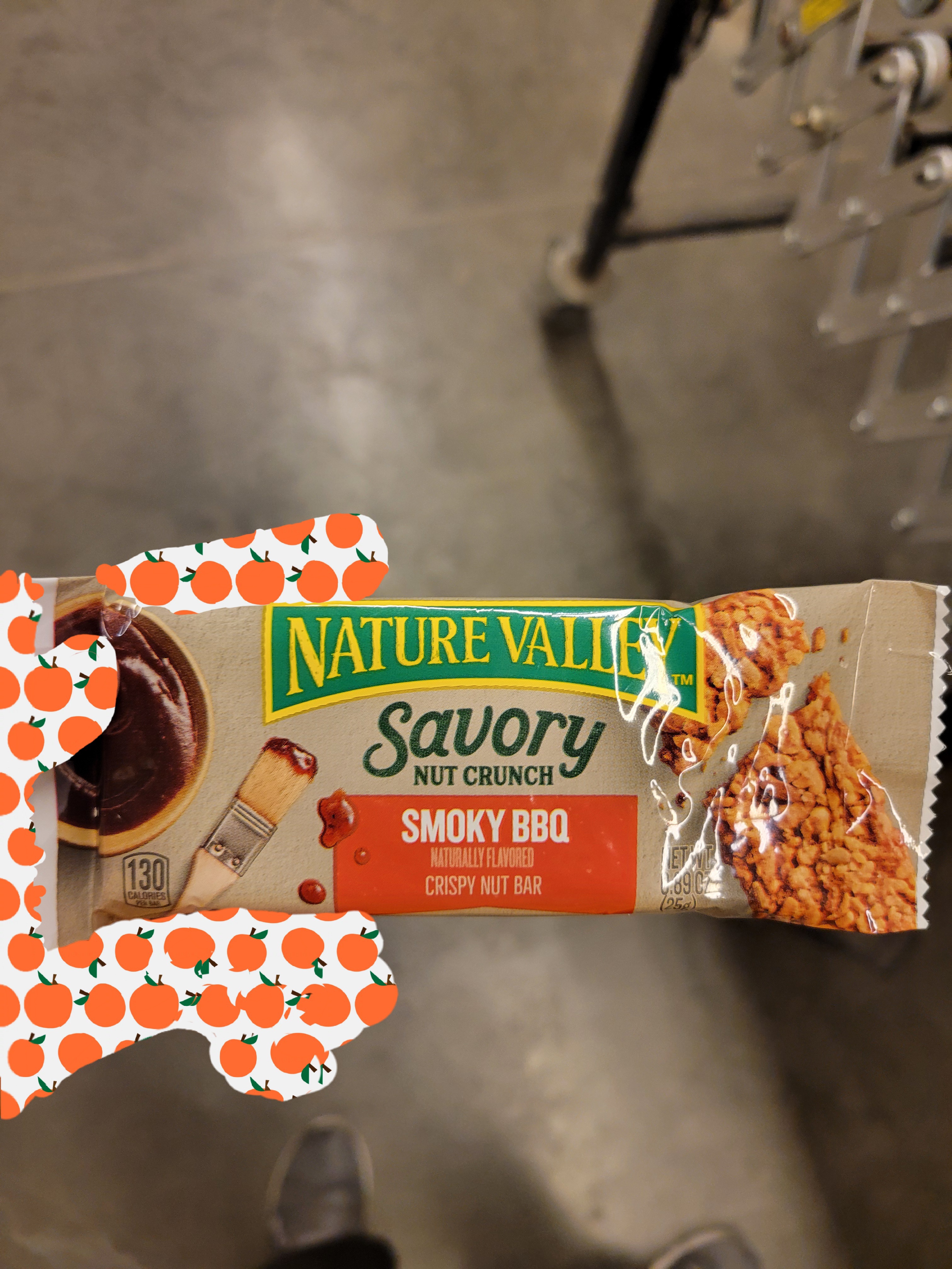 Hand holds a smokey bbq granola bar.