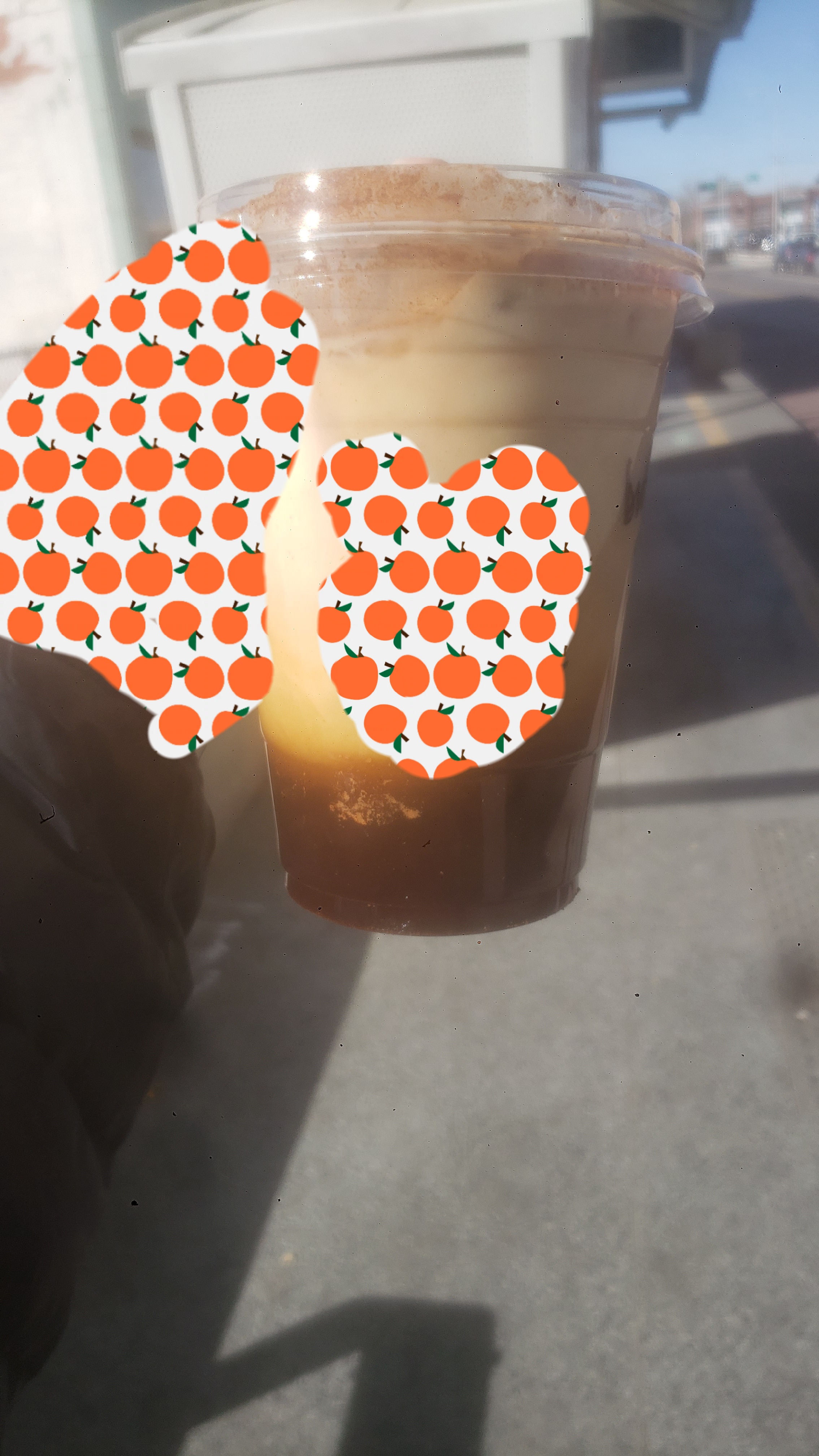 Hand holds plastic cup of shaken brown sugar espresso.