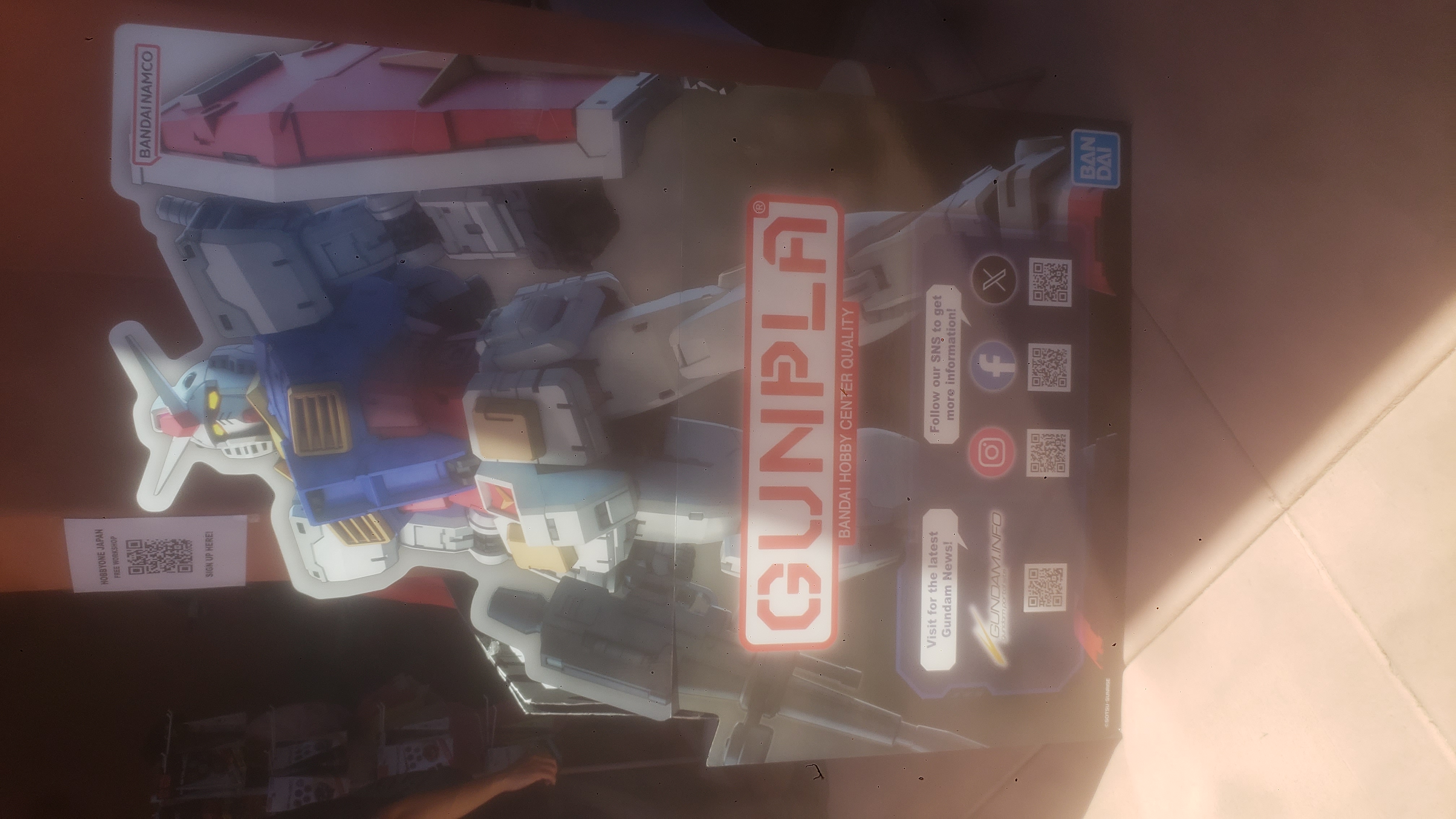 A large promotional cardboard standee for Gunpla with the RX-78-2 Gundam on it.