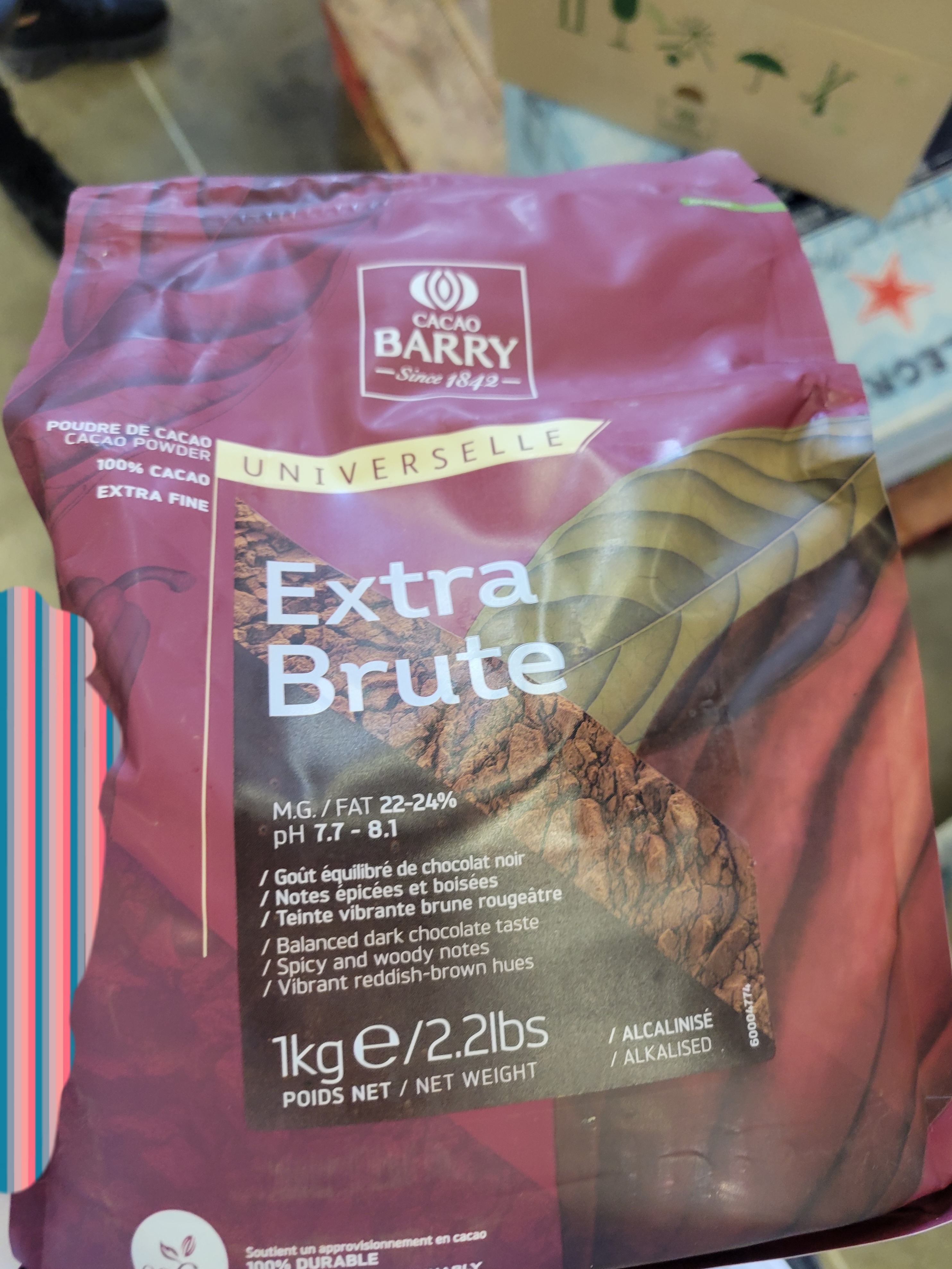 Hand holds bag of cocoa powder.