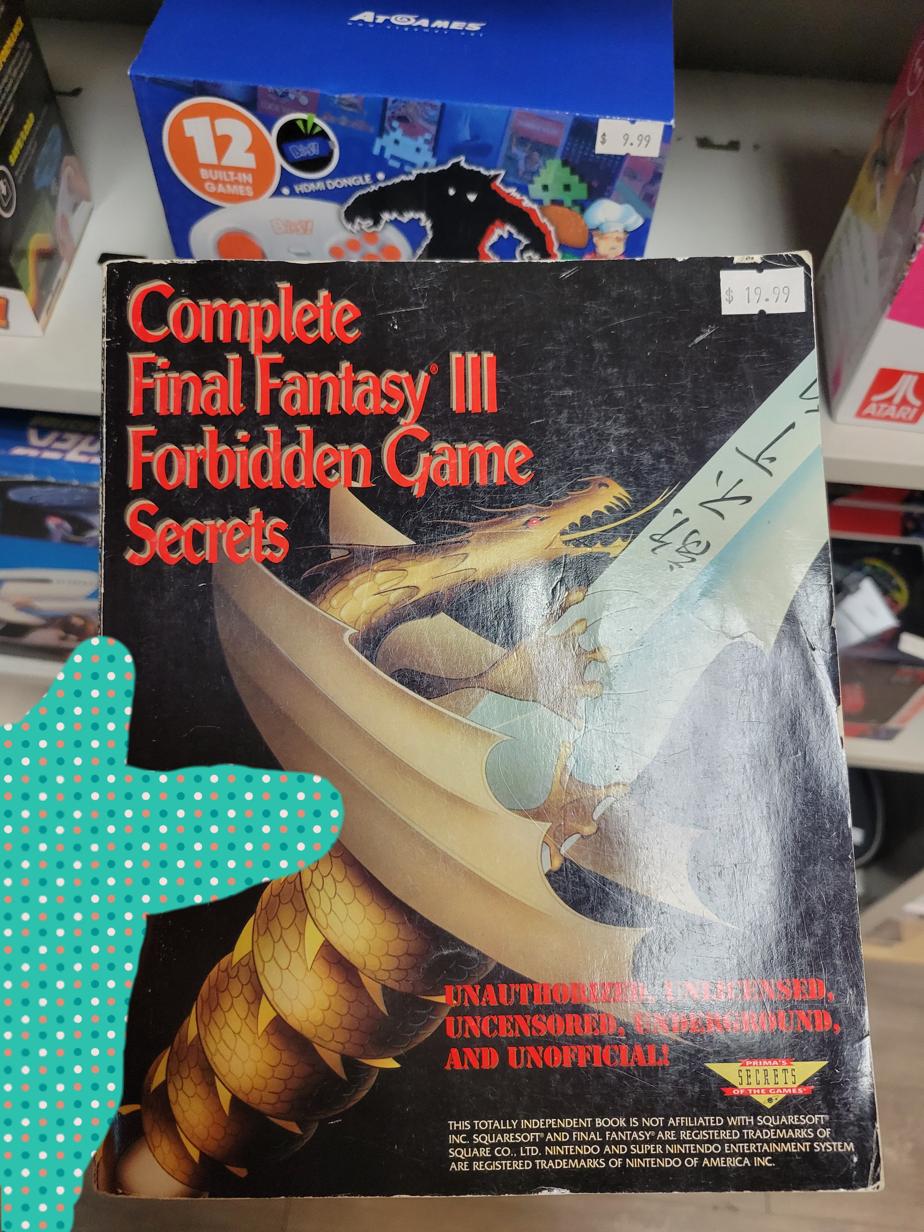 Hand holds book called Complete Final Fantasy III/VI Forbidden Game Secrets.