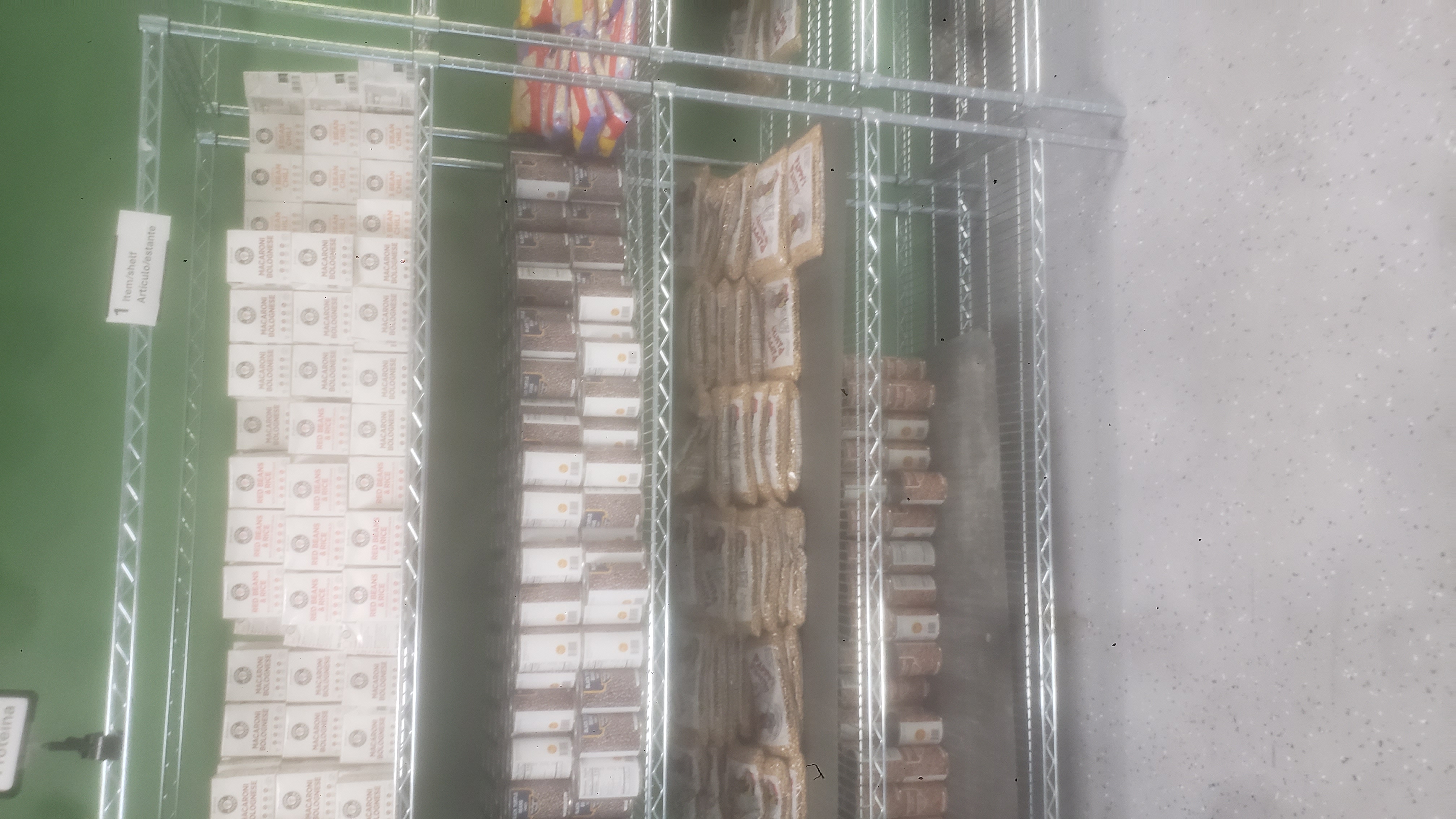 Canned pinto beans, bags of chickpeas, canned black turtle beans, and ready-to-eat meals on a four tier shelf.