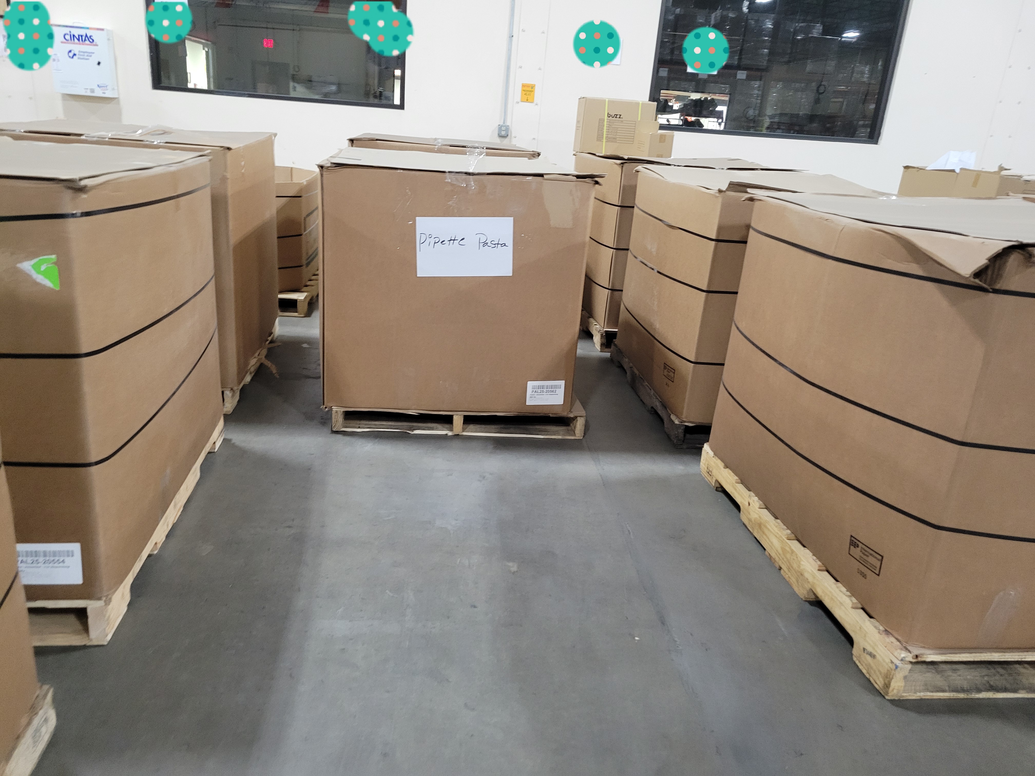 Cardboard containers full of different pastas and signs listing what kind on them.