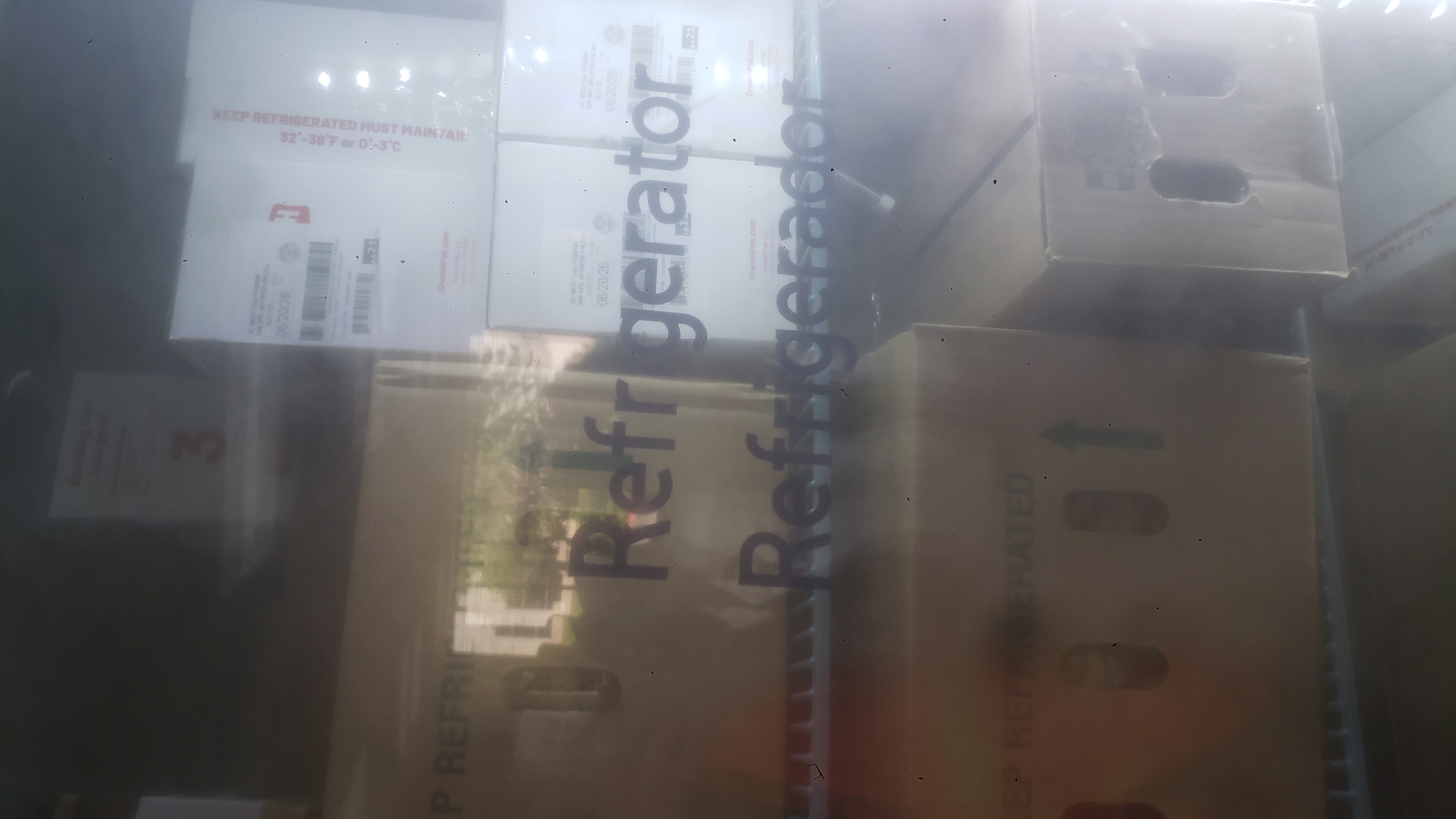 Cardboard boxes on shelves of a fridge.