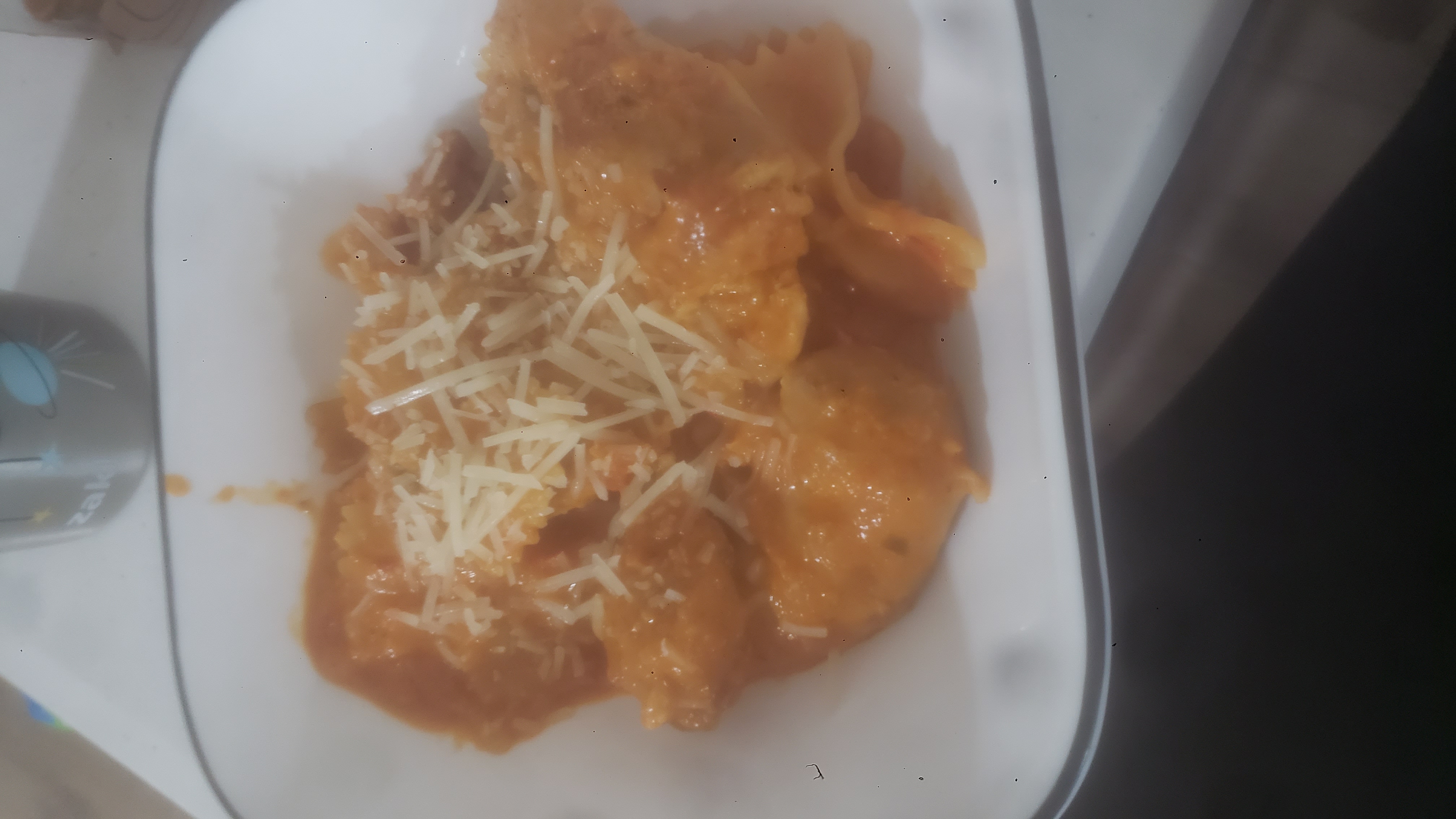 Bowl of pasta, sauce, and shredded cheese.