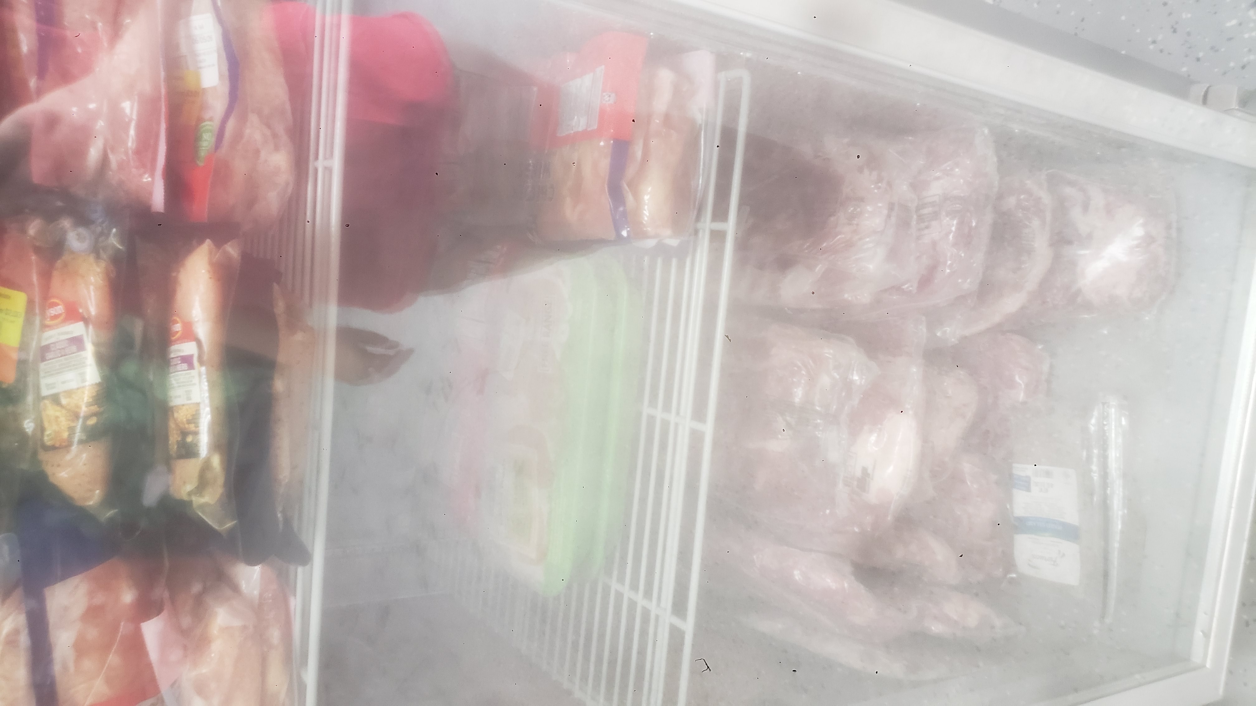 Various meats in a fridge.