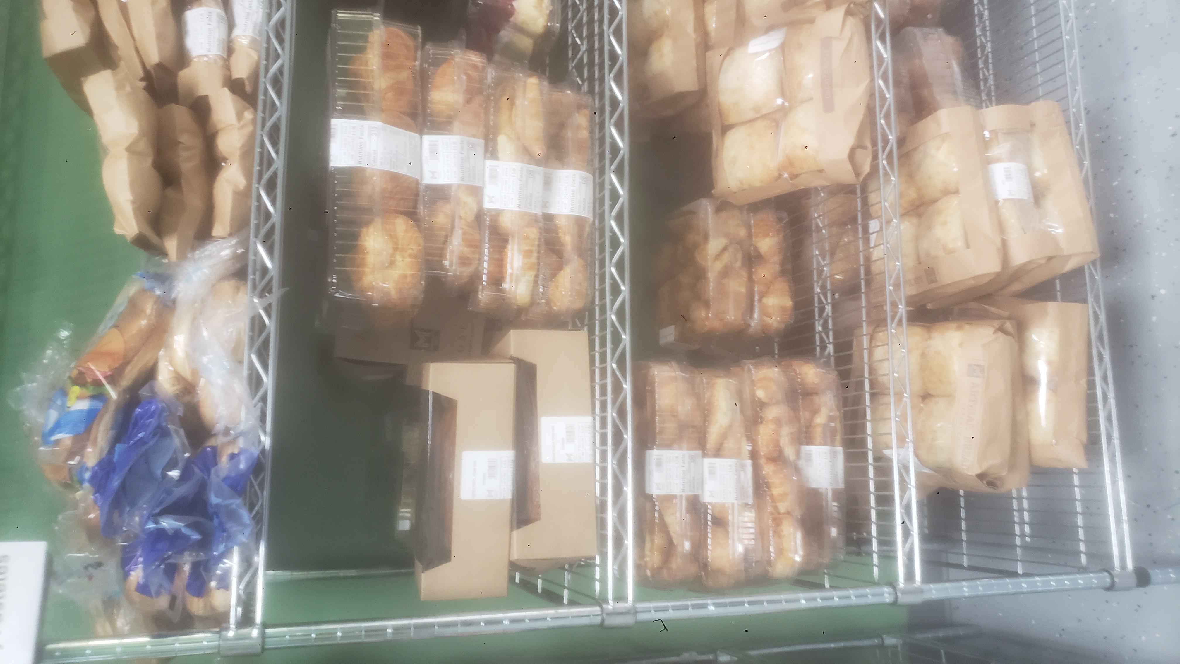 Assorted baked goods on racks of a shelf.