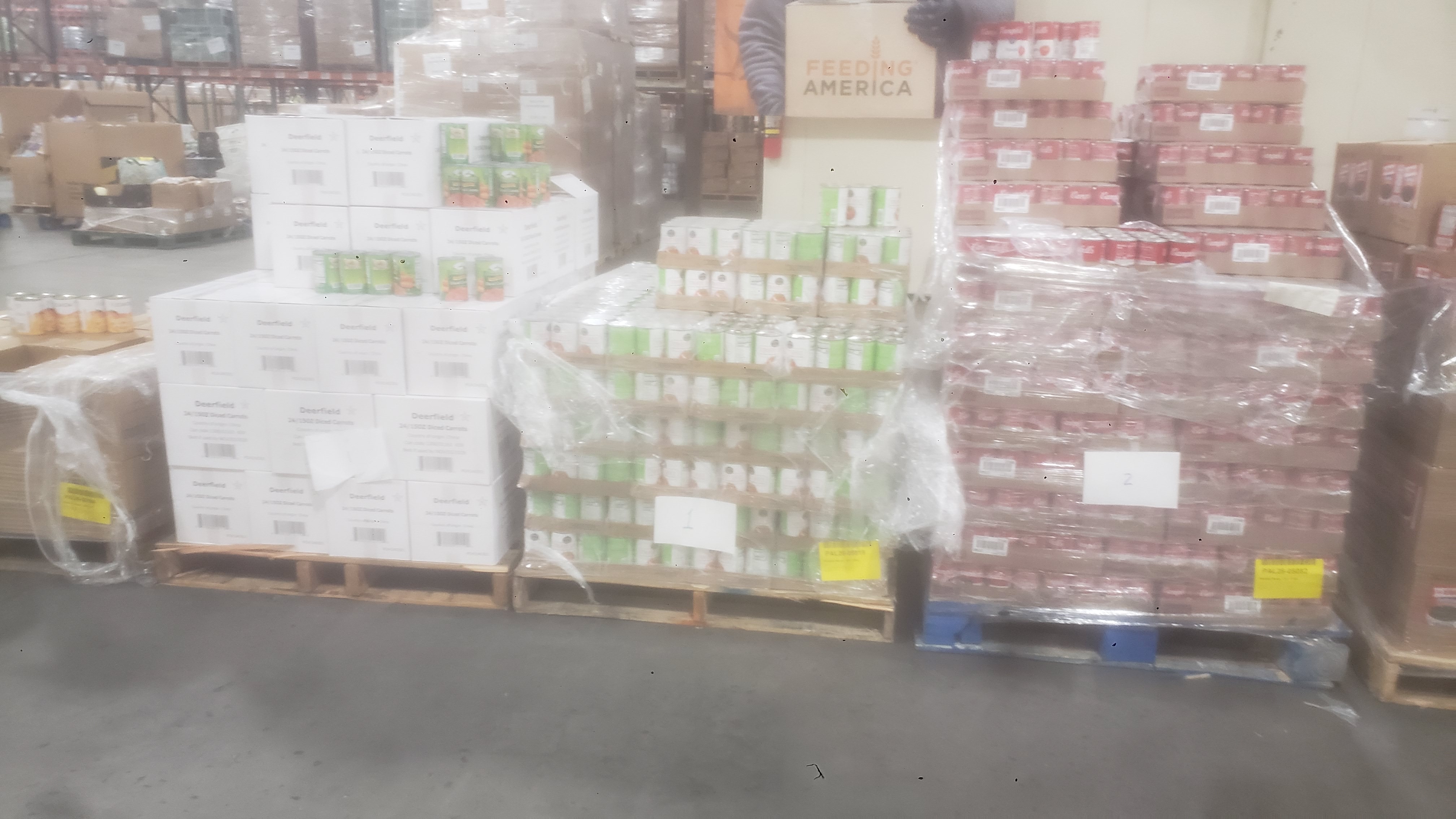 Pallets of boxes and trays of canned goods.