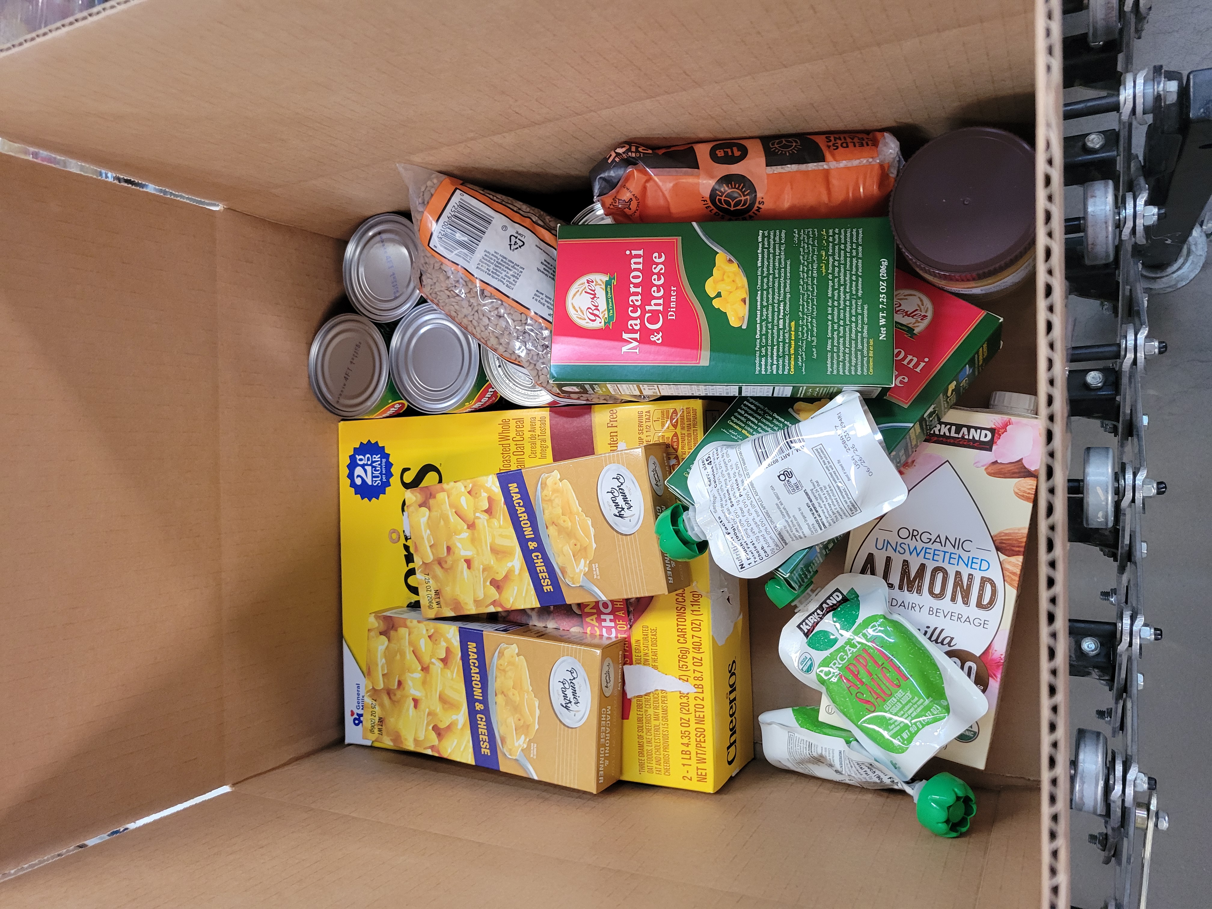 Cardboard box filled with dry goods on a conveyor belt.