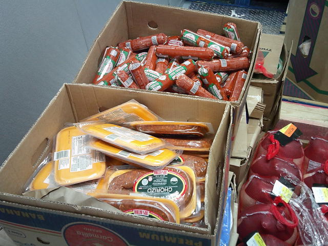 Packs of chorizo in casing and log forms of chorizo in banana boxes.
