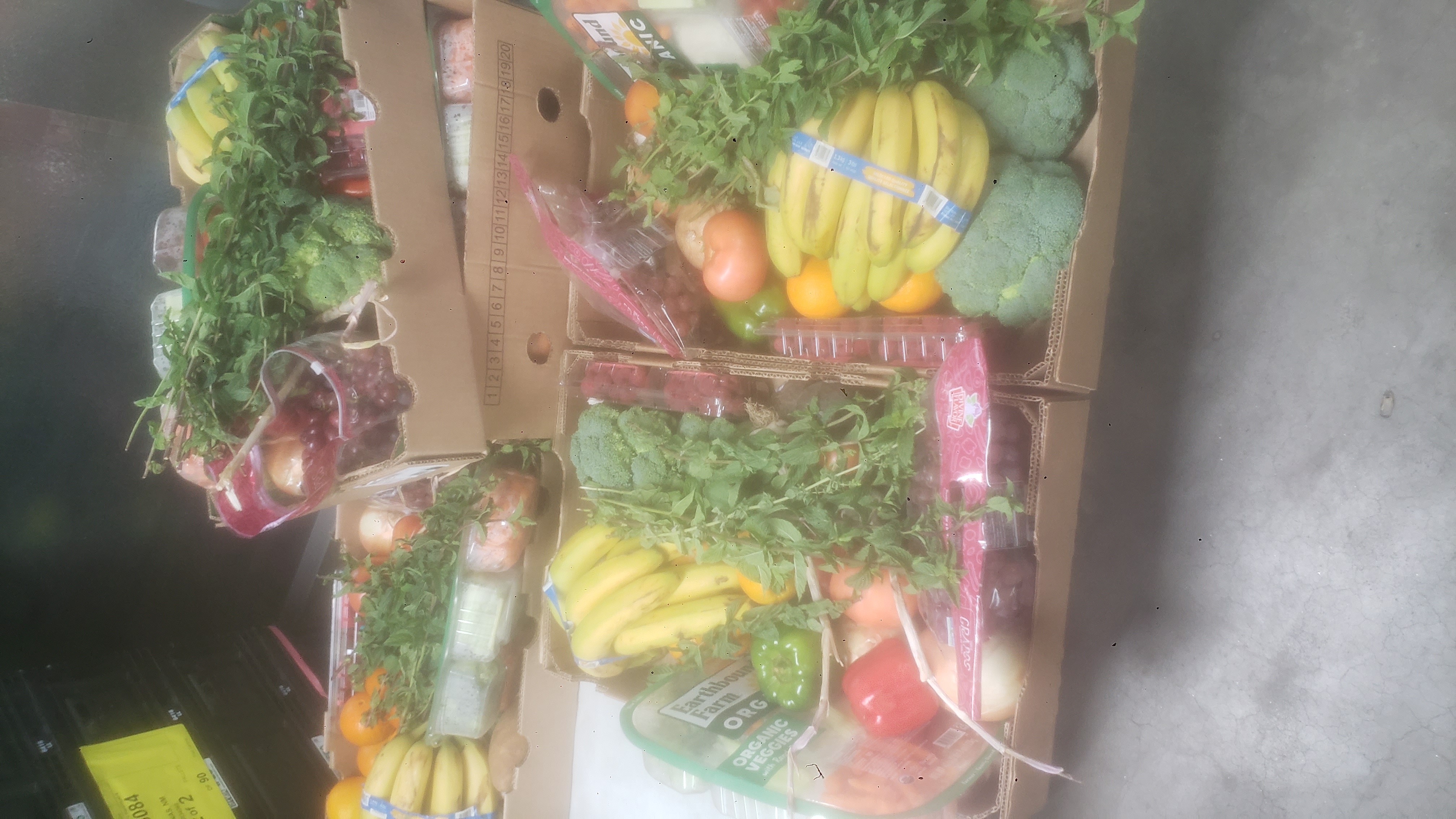 Cardboard trays and banana boxes full of produce.