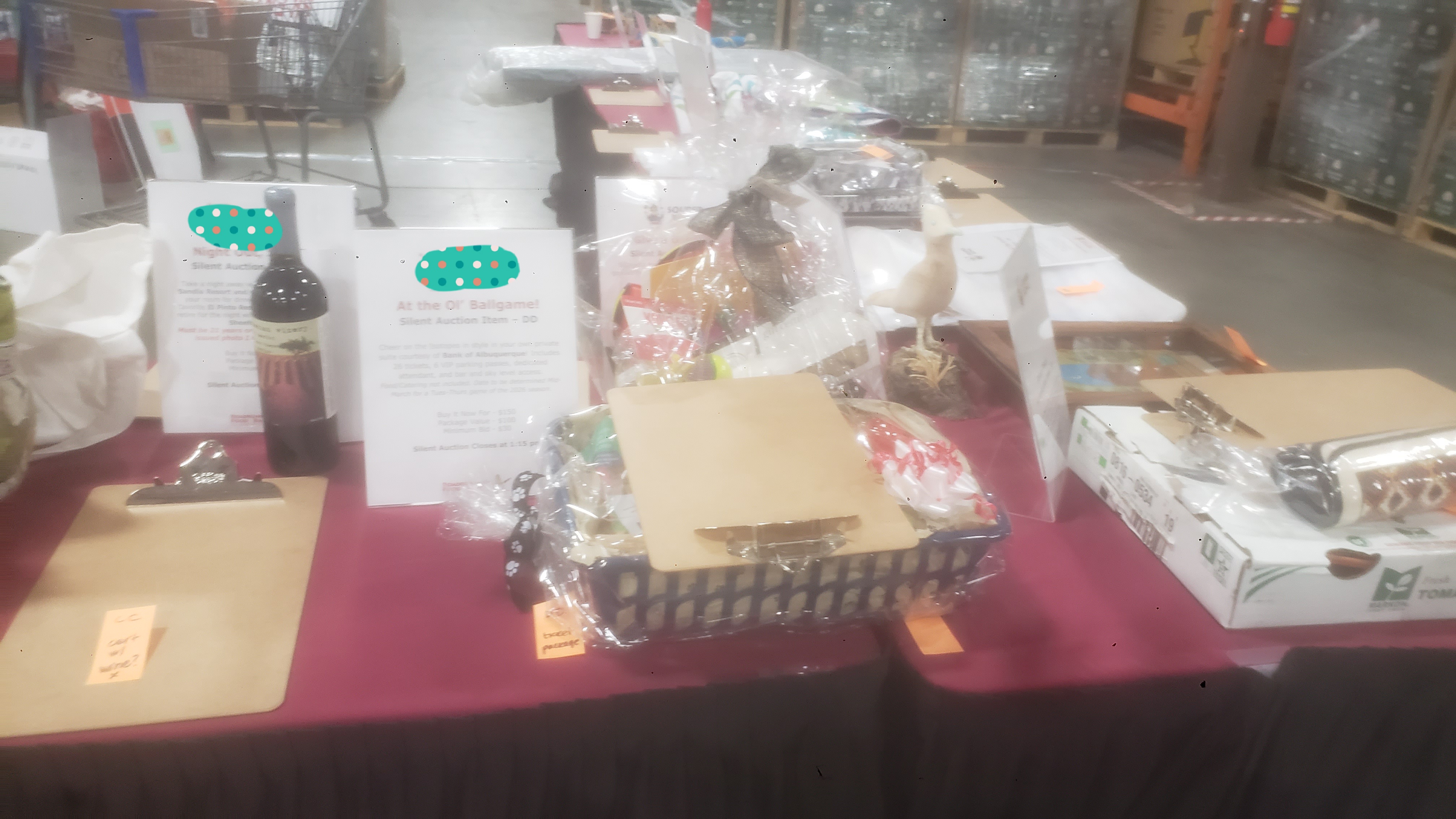 Assorted prizes such as wine and gift bags with signs on table.