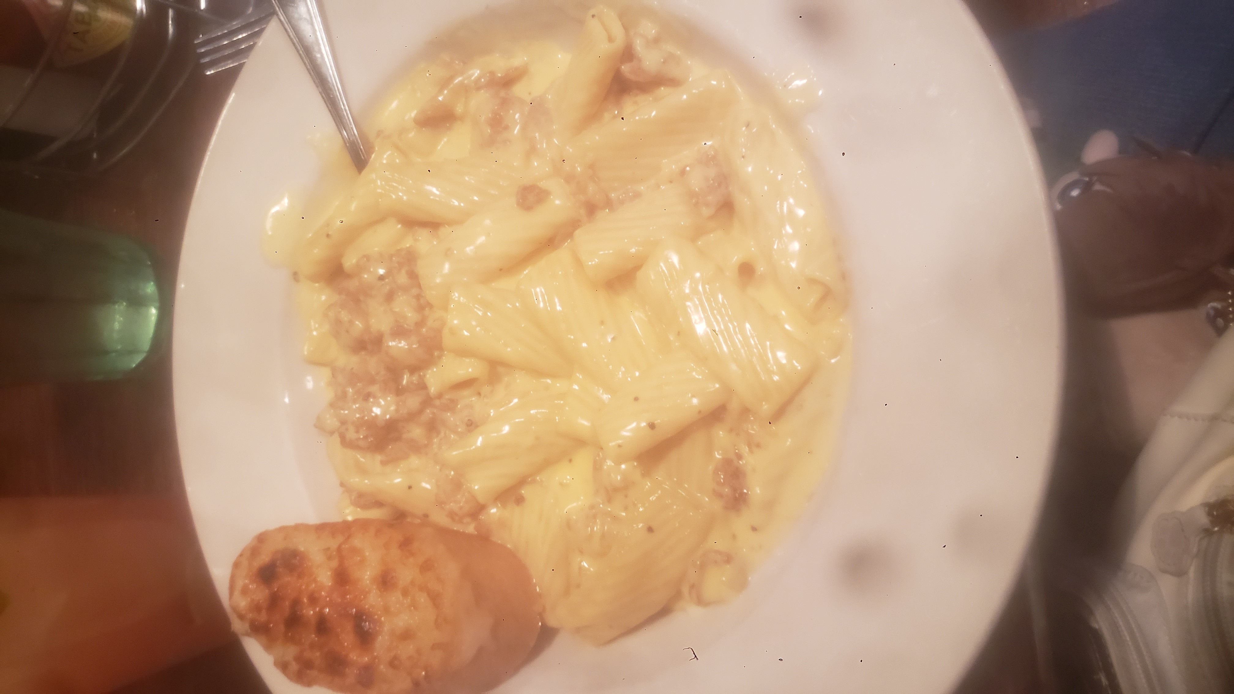 Lobster mac n cheese with a toasted bread on a plate.