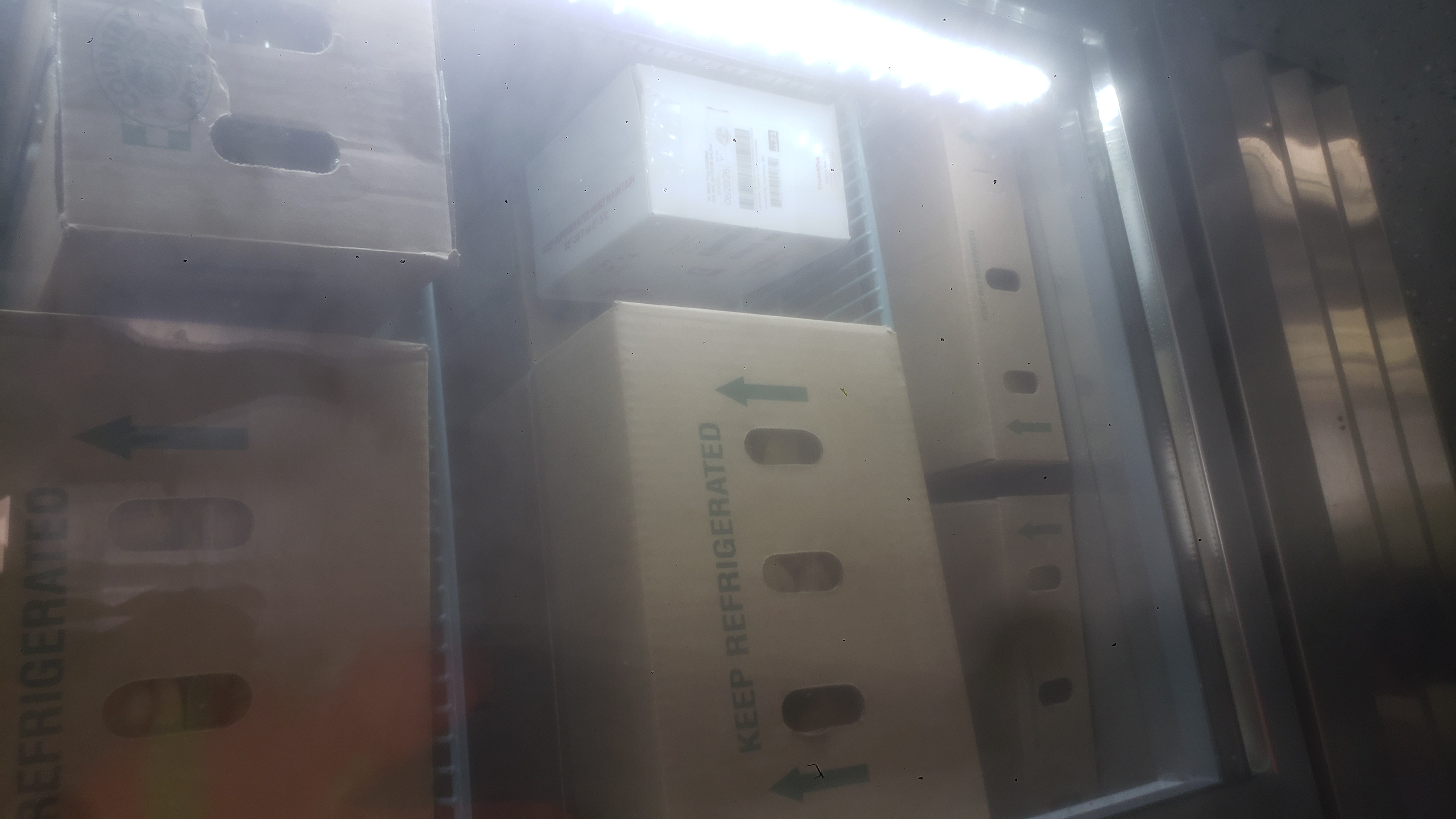 Cardboard boxes on shelves of a fridge