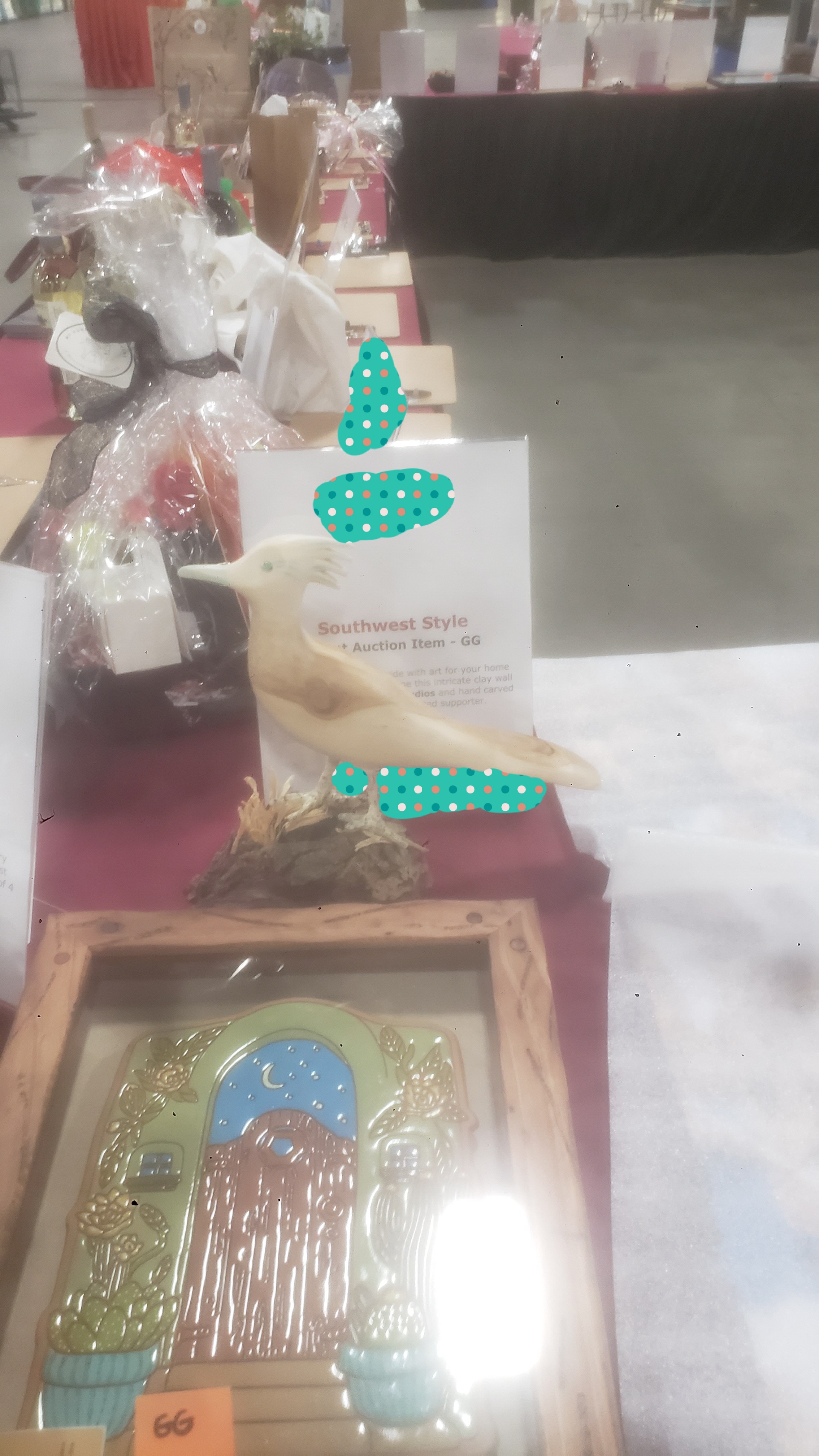 Silent auction items such as food on a table with signs.