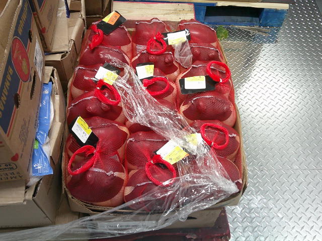 Whole mysterious meats wrapped in netting in a cardboard tray.