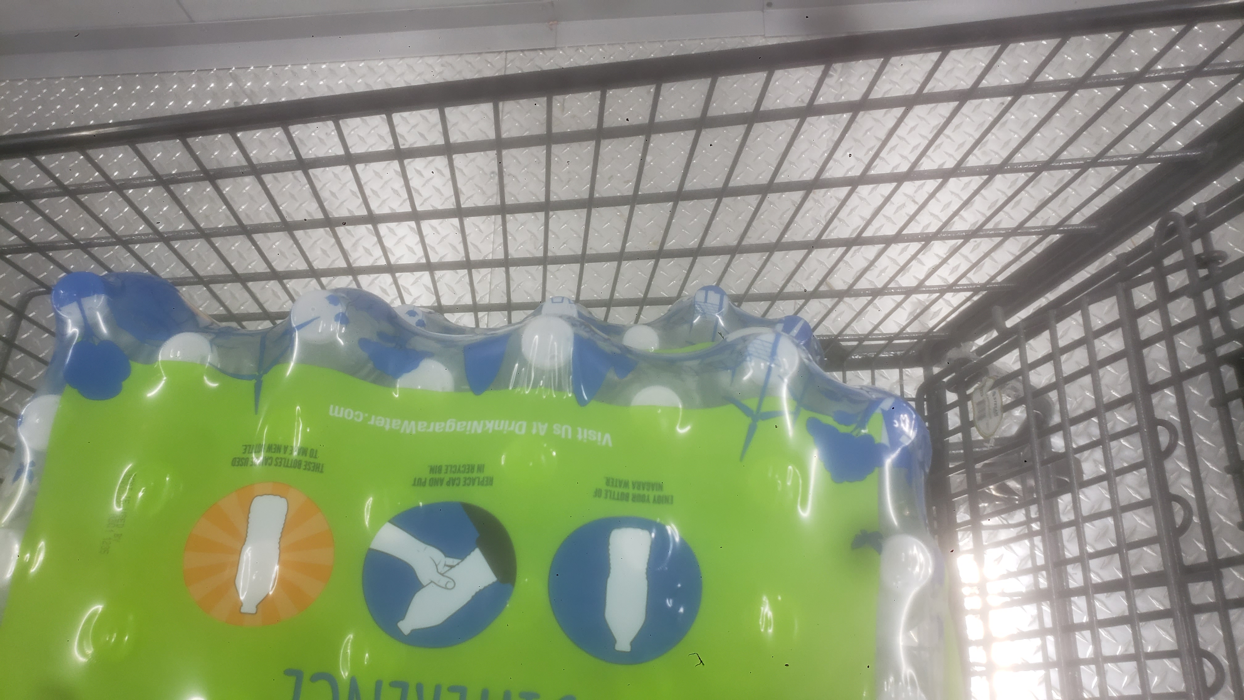 Case of water bottles in a shopping cart.