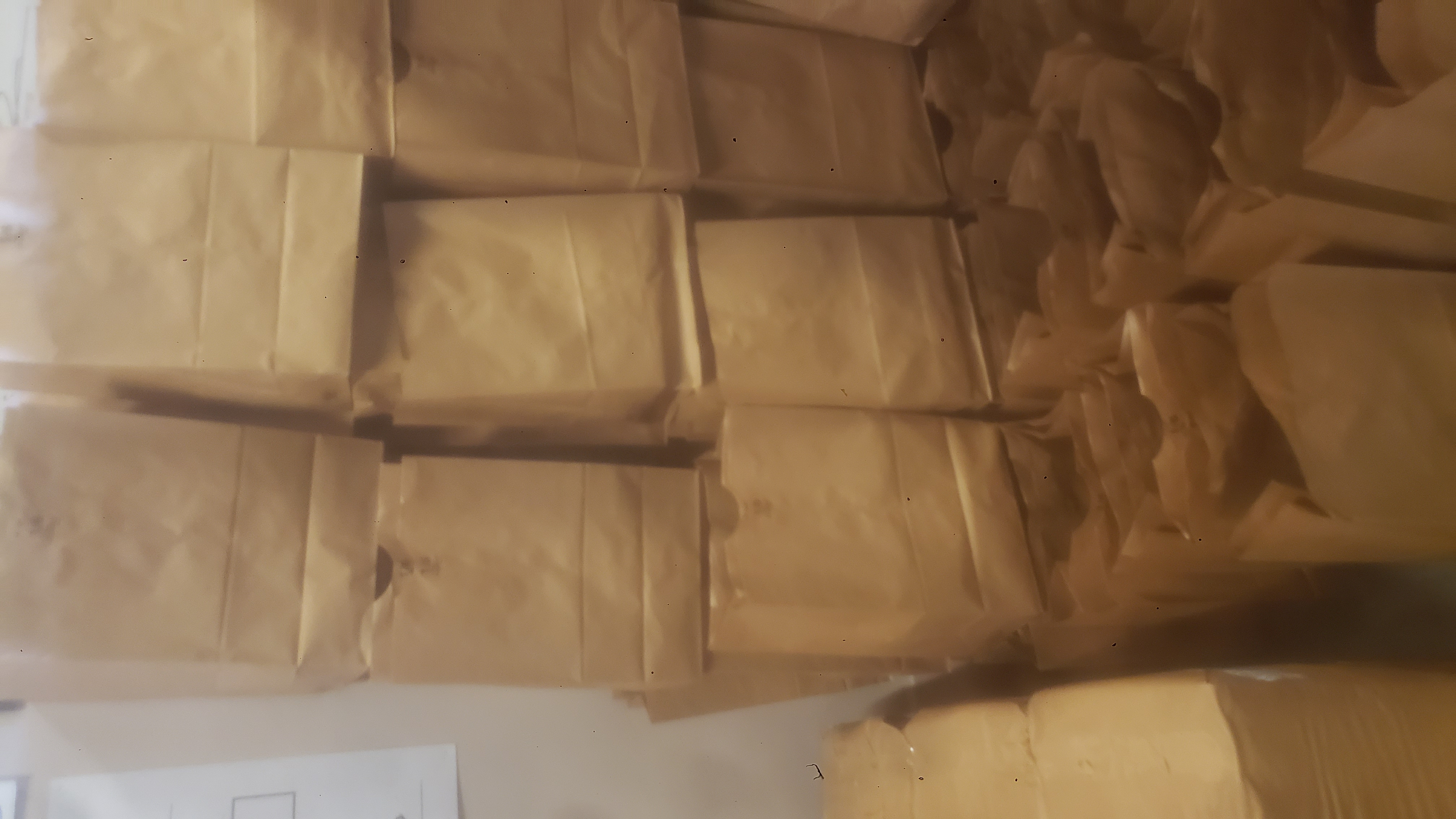 Rows of paper bags with some stacked on each other.