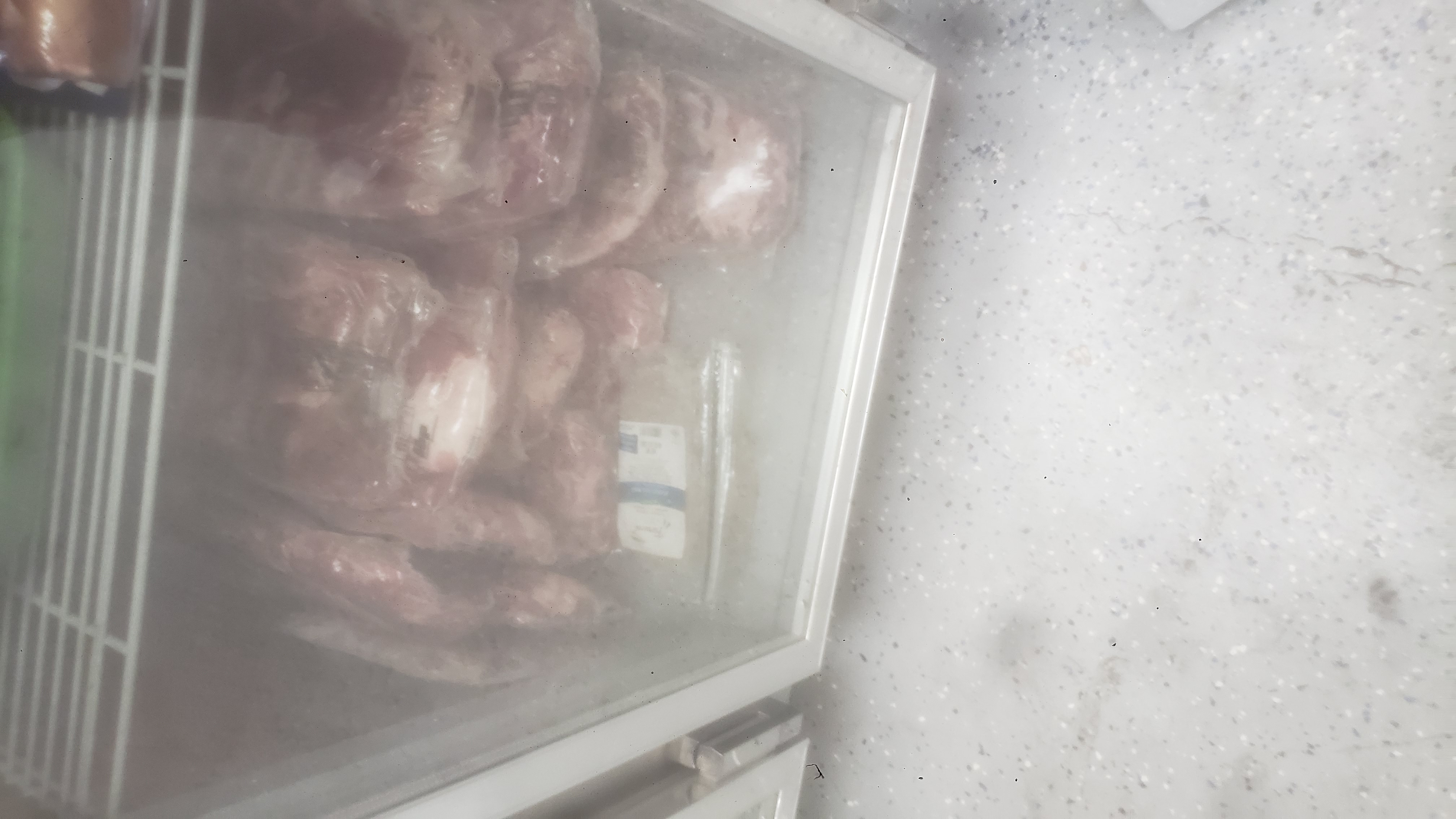 Various meats in a fridge.