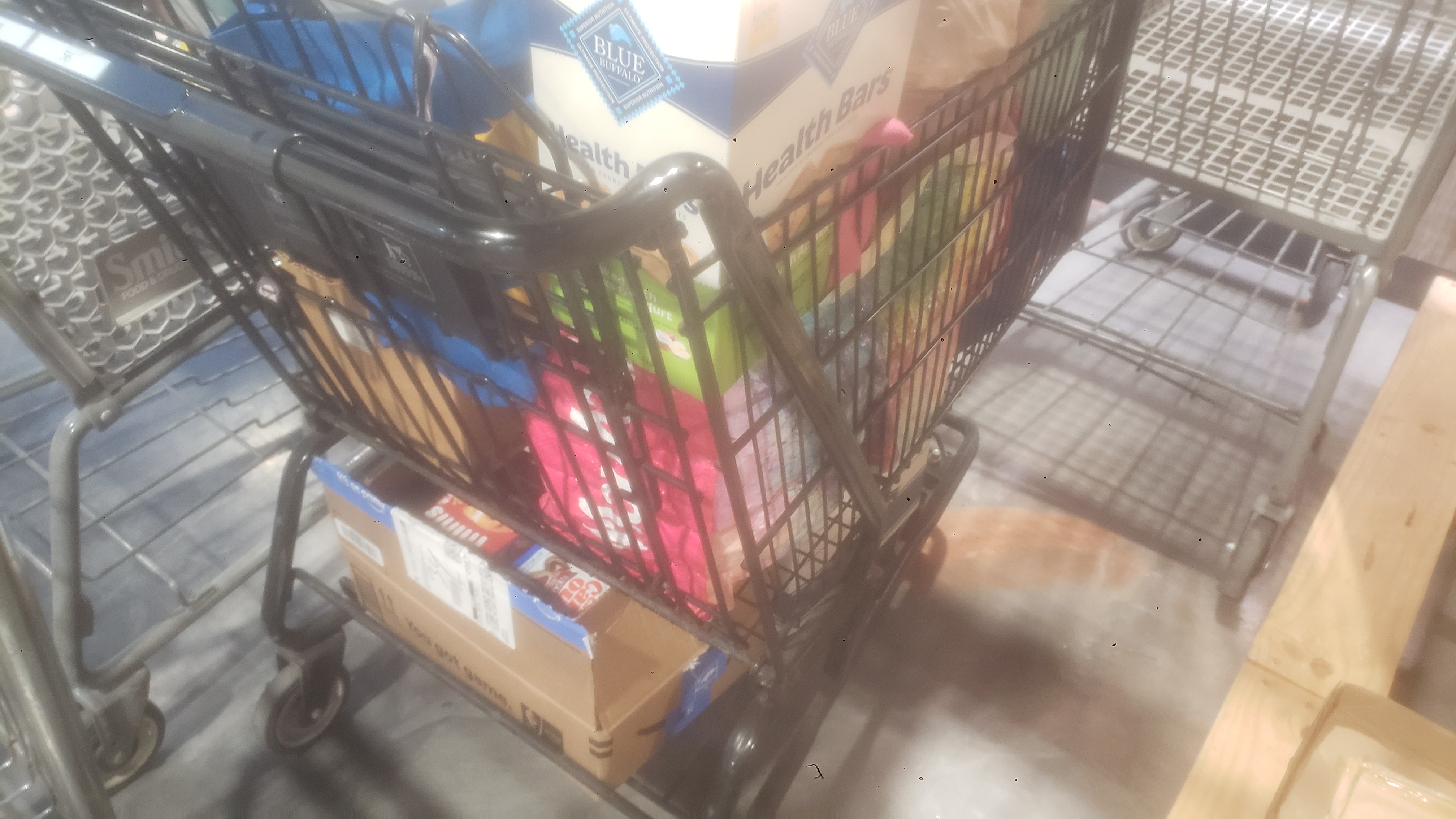 Items such as box of dog foods in a shopping cart.