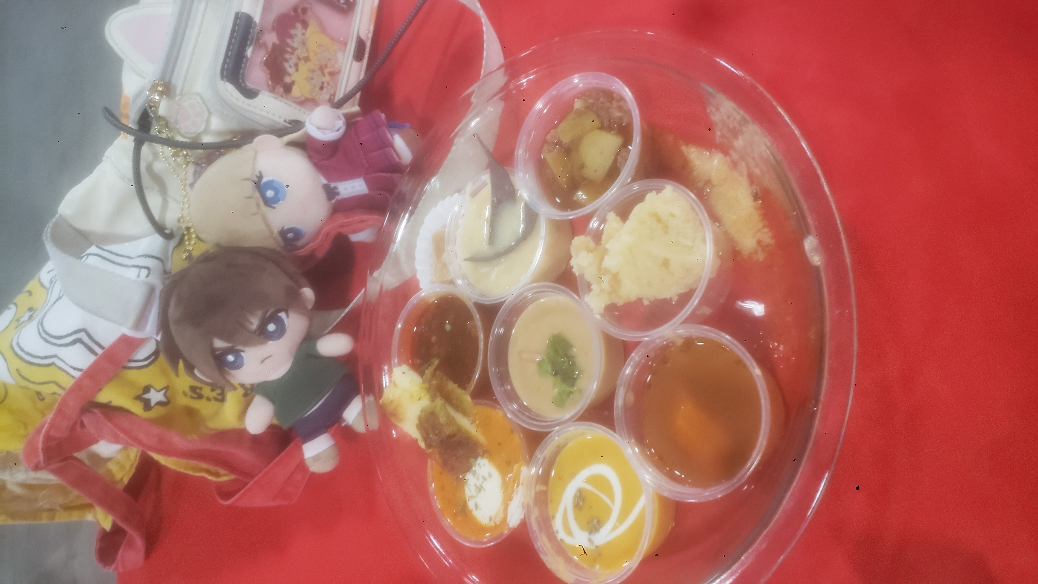 Pie tin full of mini cups of soup and mini desserts on a table.