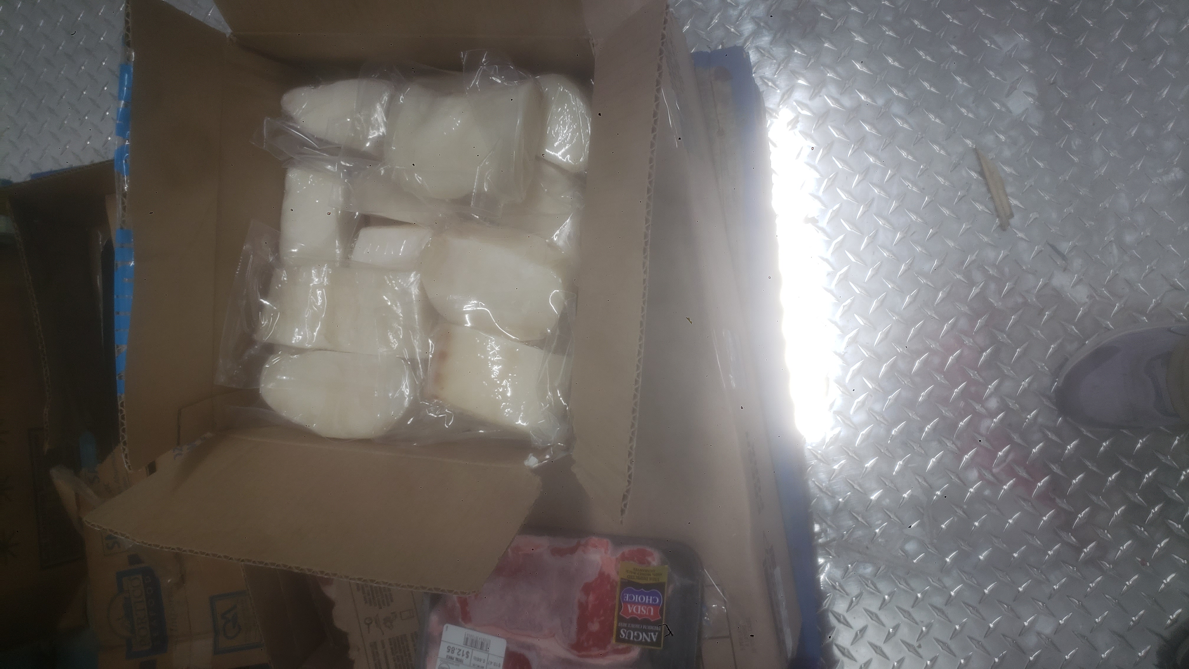 Cardboard box filled with vacuum-sealed fish fillets.