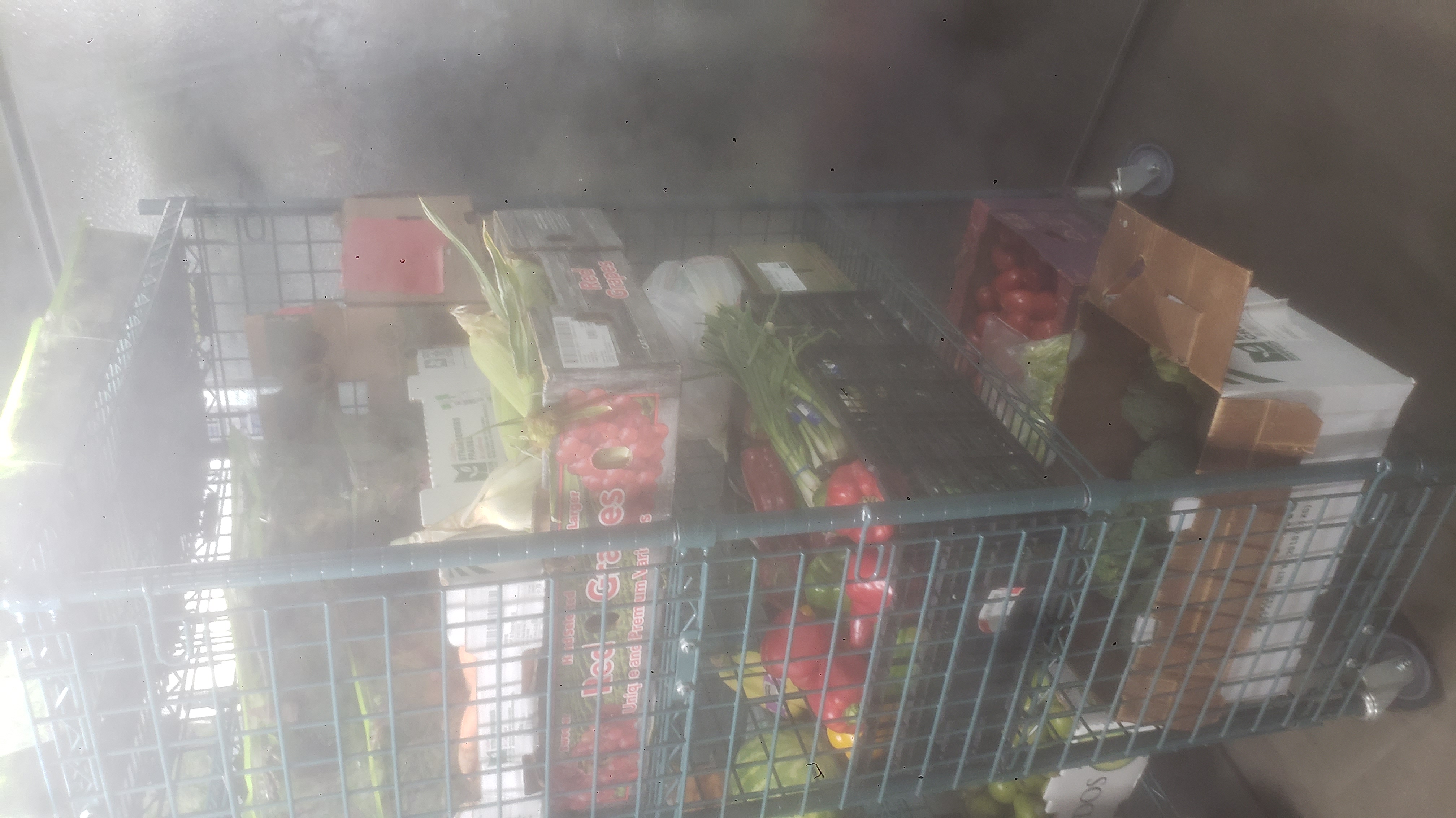 Assorted produce on shelves of a cage shelf.
