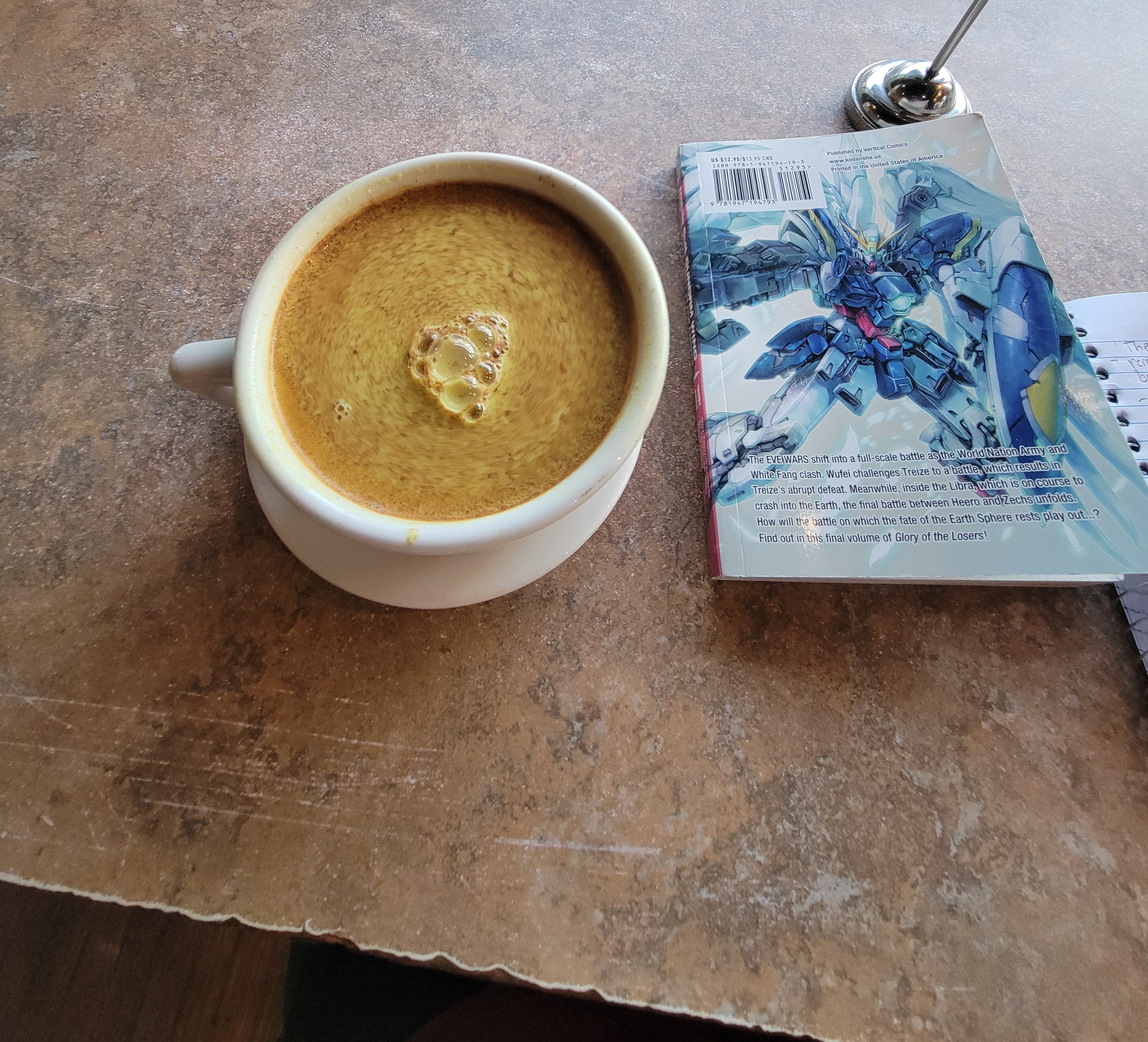 Cup of golden milk next to the back cover of Gundam Wing Glory of Losers volume 14.