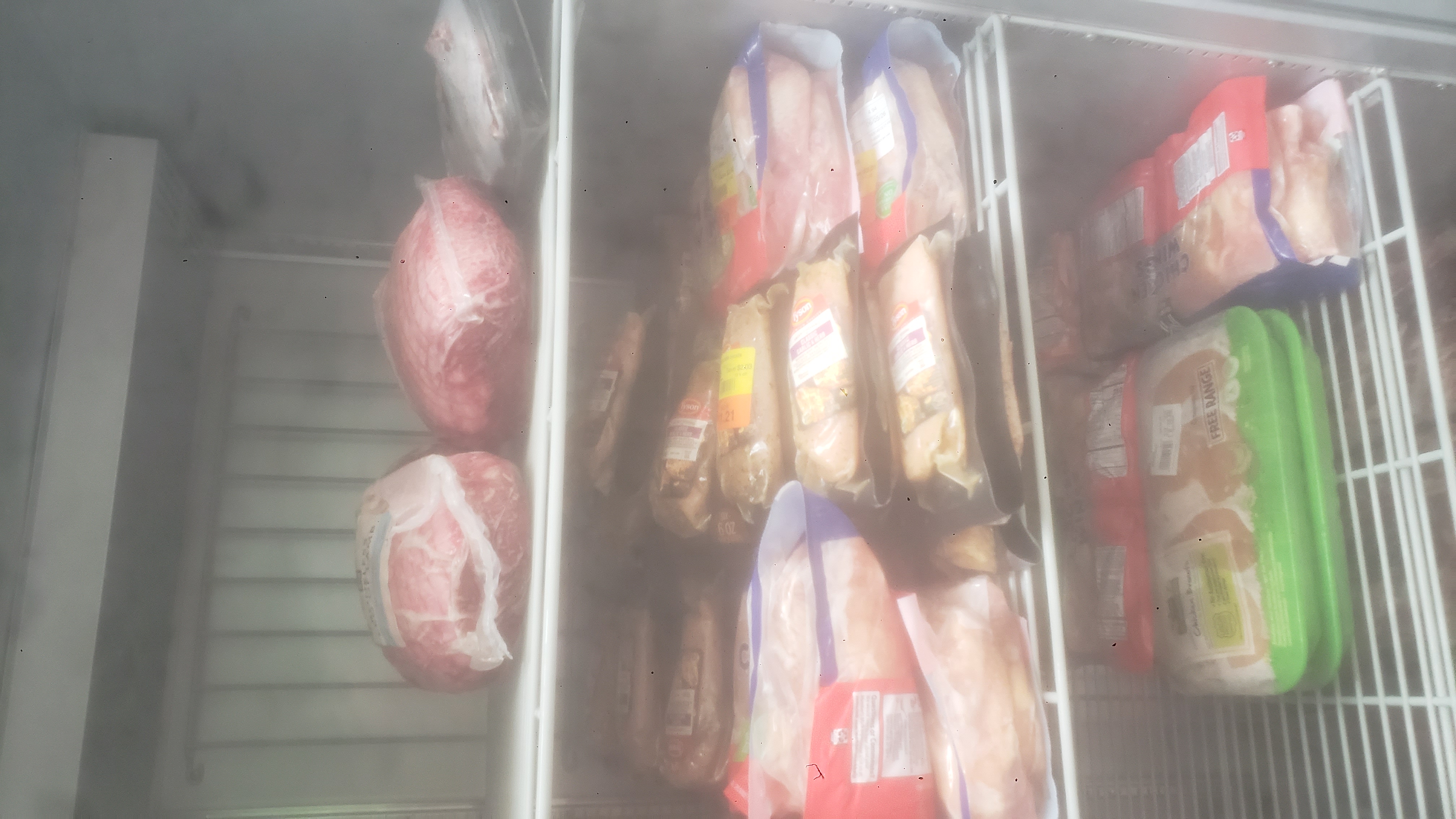 Various meats in a fridge.