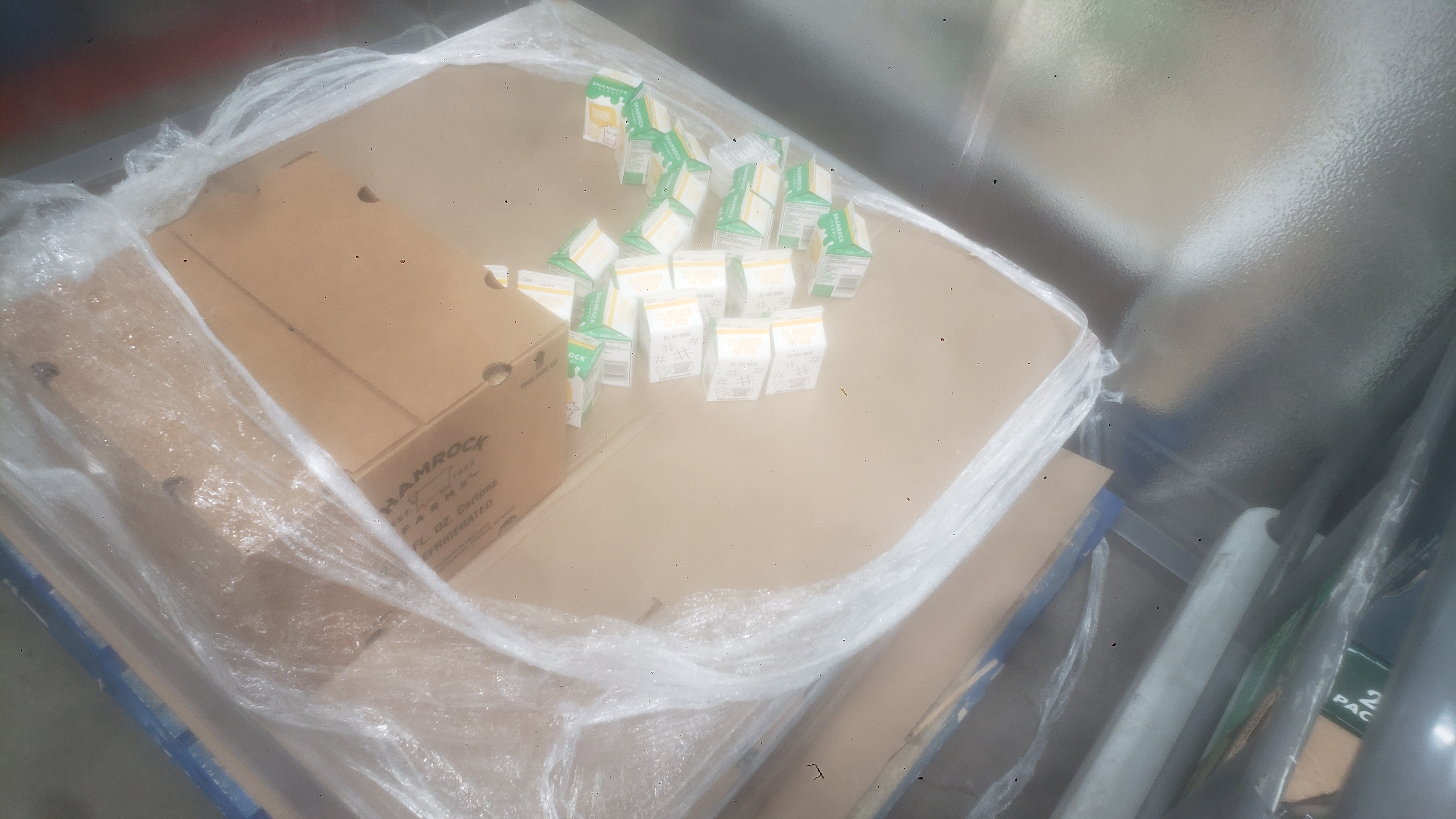 Cardboard box and 2% reduced fat half pint milk cartons on a pallet.