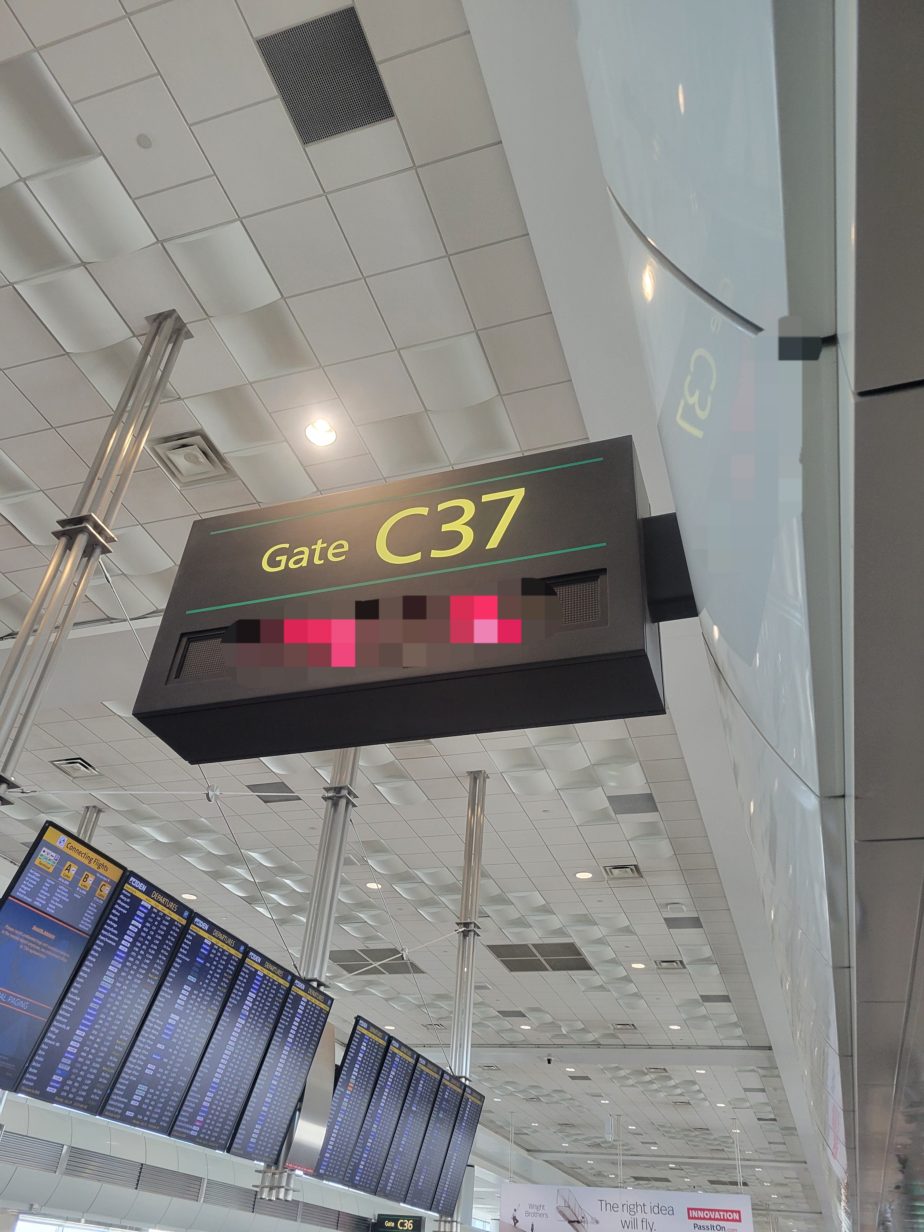 Airport sign for gate C37 with the destination city under it.