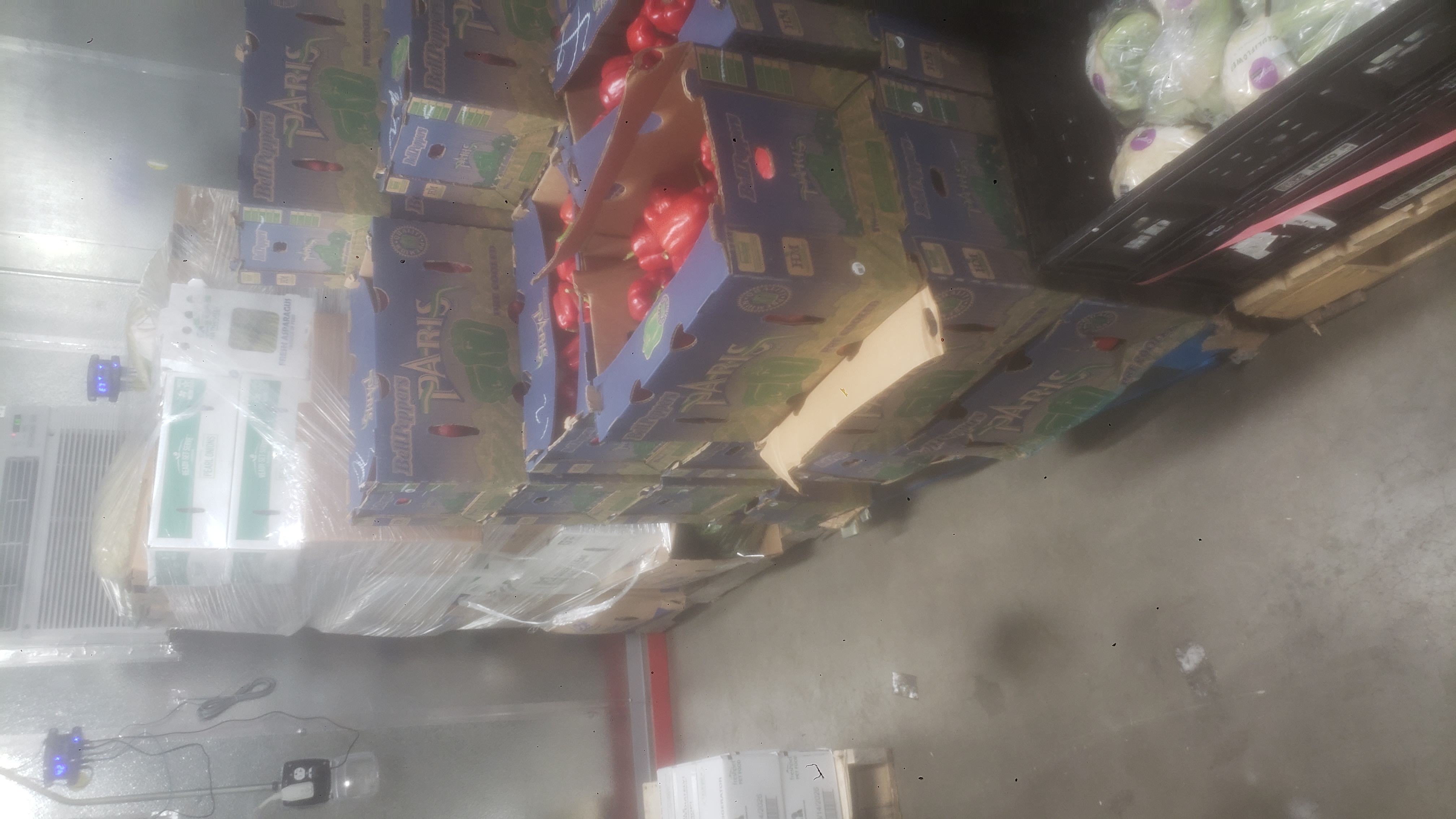 Cardboard boxes, trays, and crates full of produce.