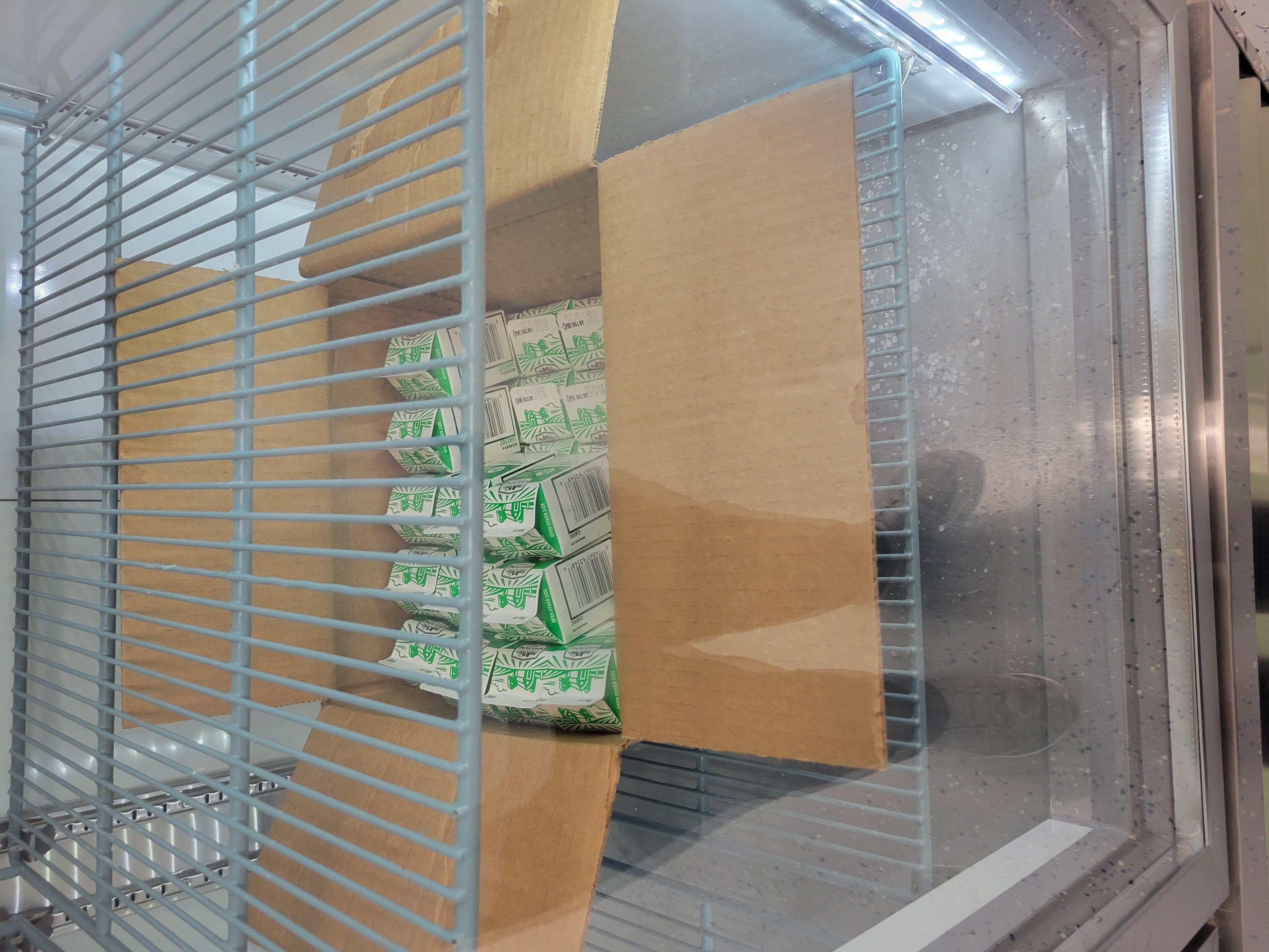 Cardboard box filled with half pint cartons of milk.