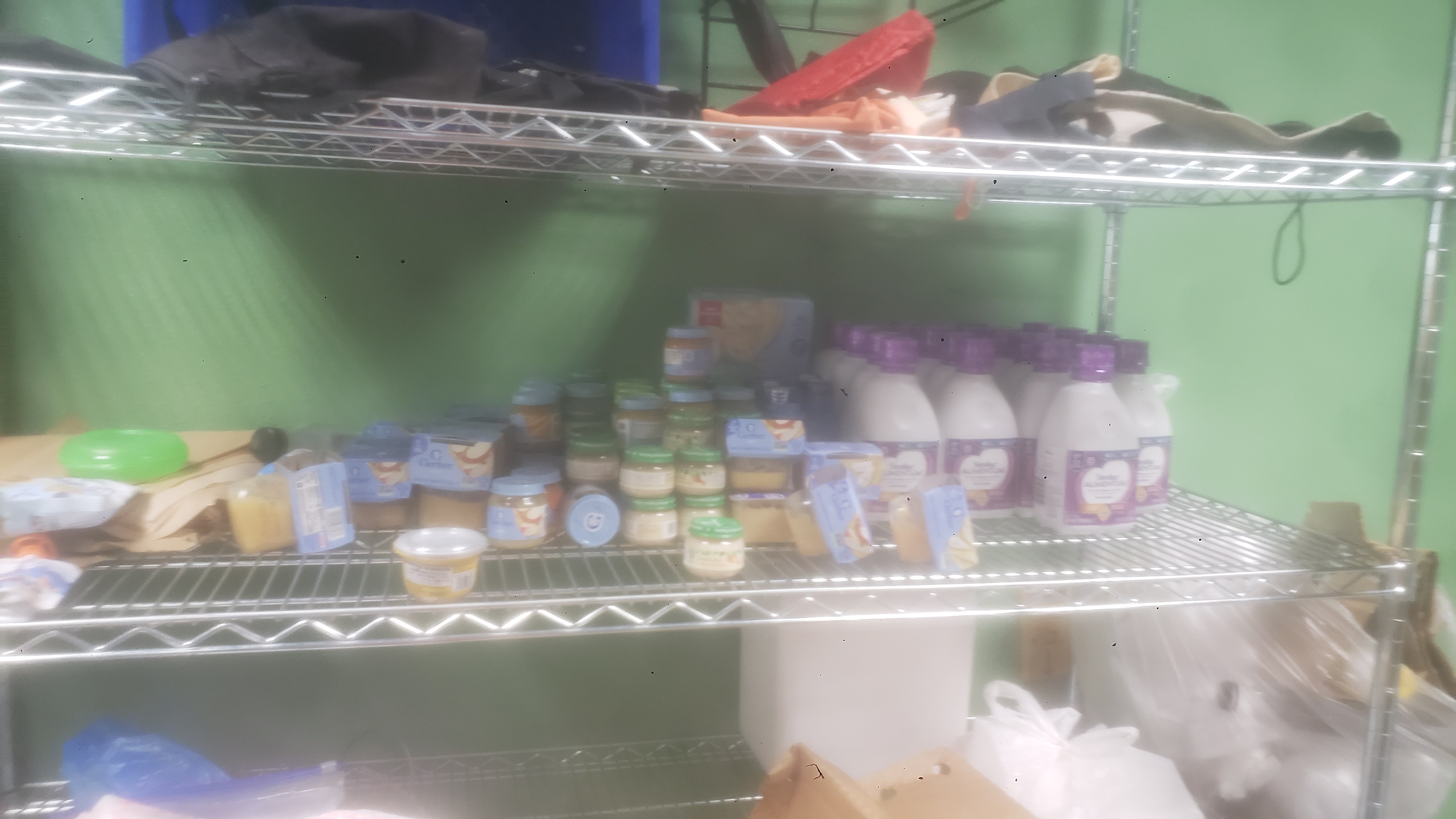 Baby food and formula on a shelf.