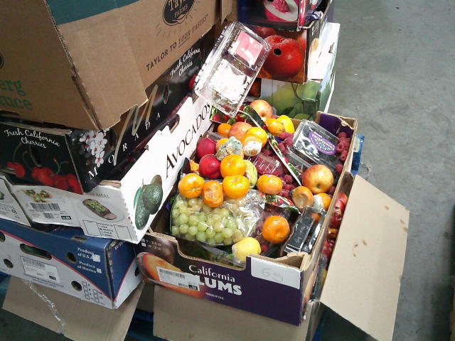 Stacks of produce trays full of rotten produce.