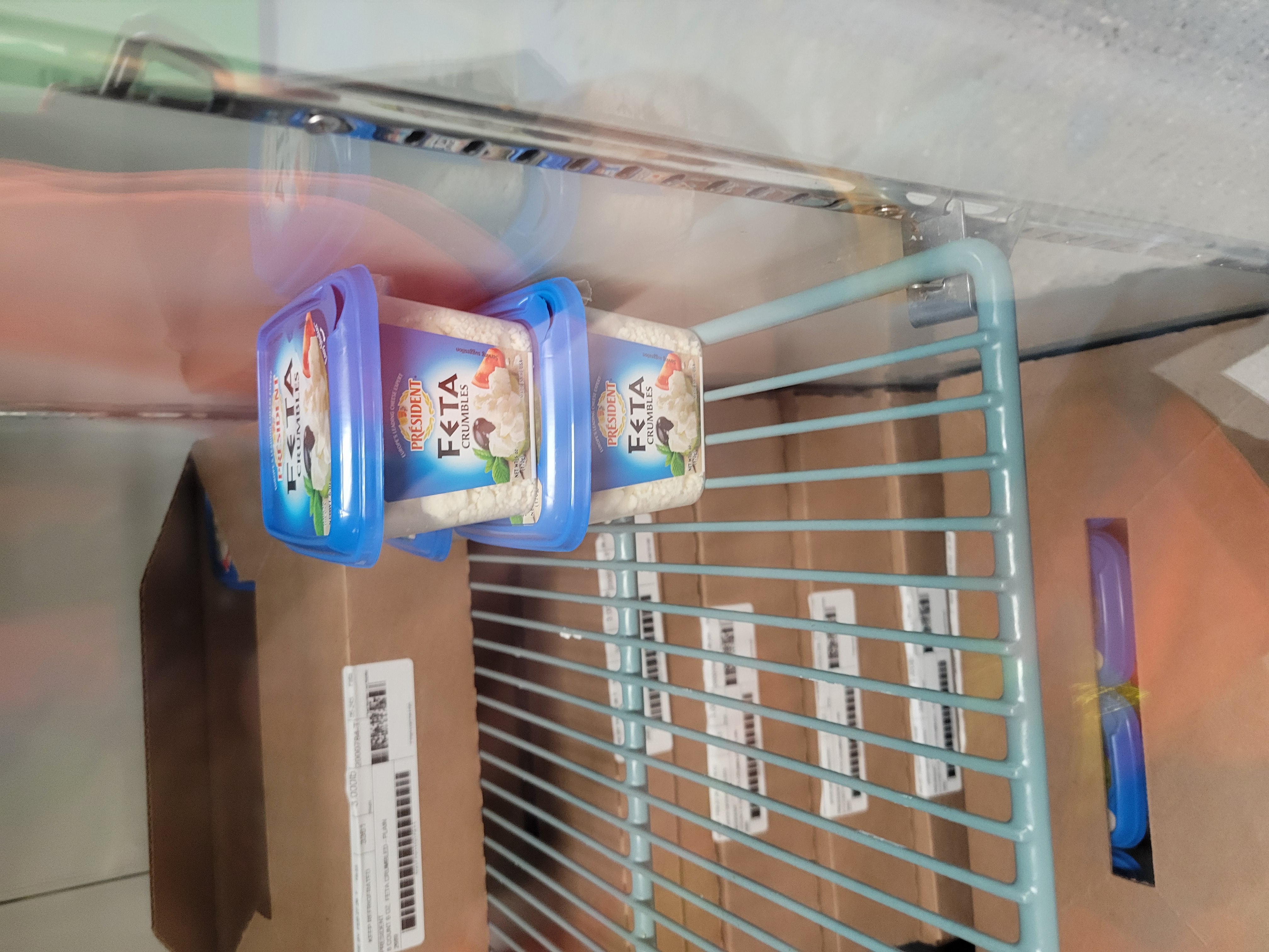 Boxes of small feta cheese containers in a fridge.